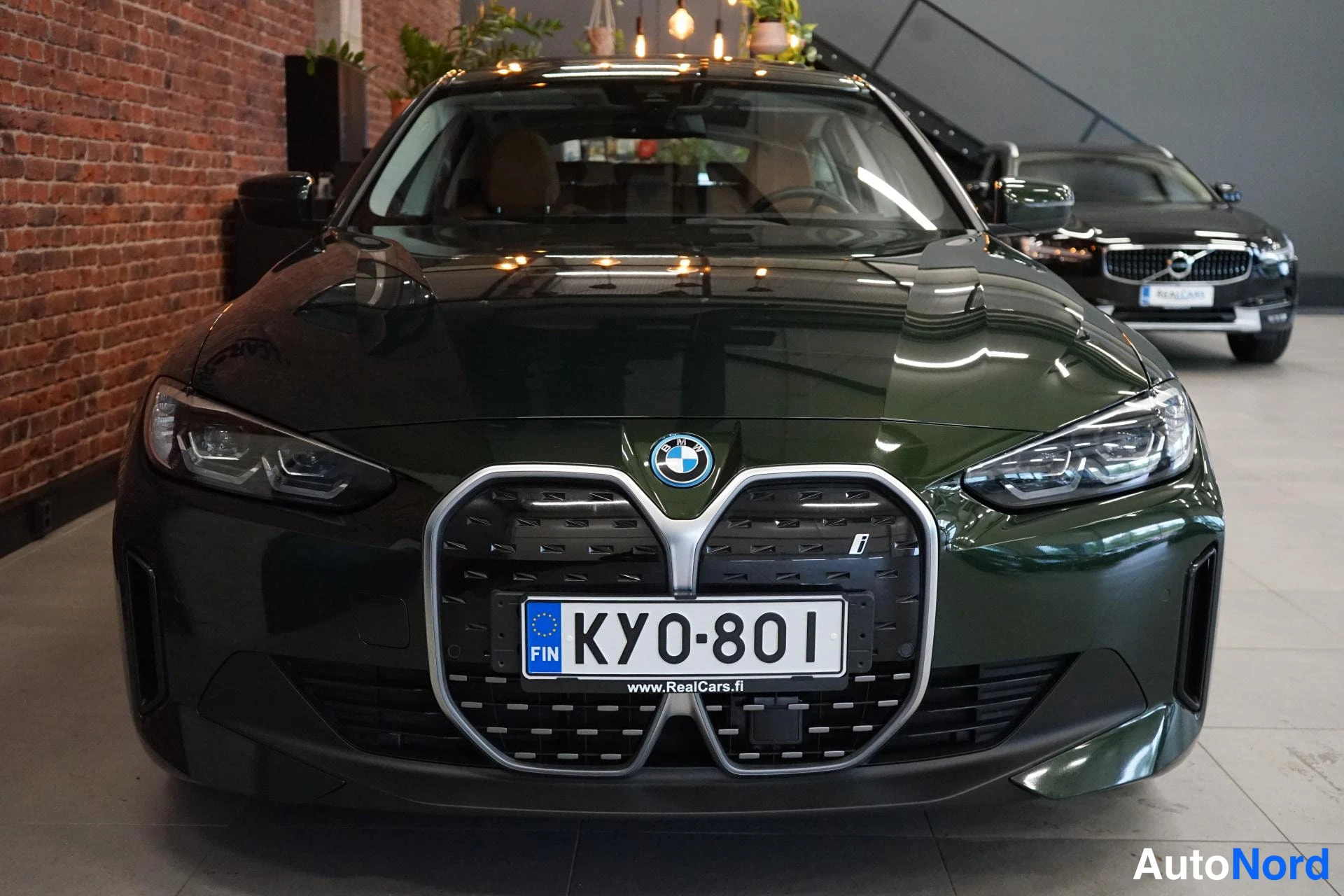 Edestä: Tummanvihreän autin etunäkymä suljetuilla munuaisgrilleillä ja BMW-emblemalla