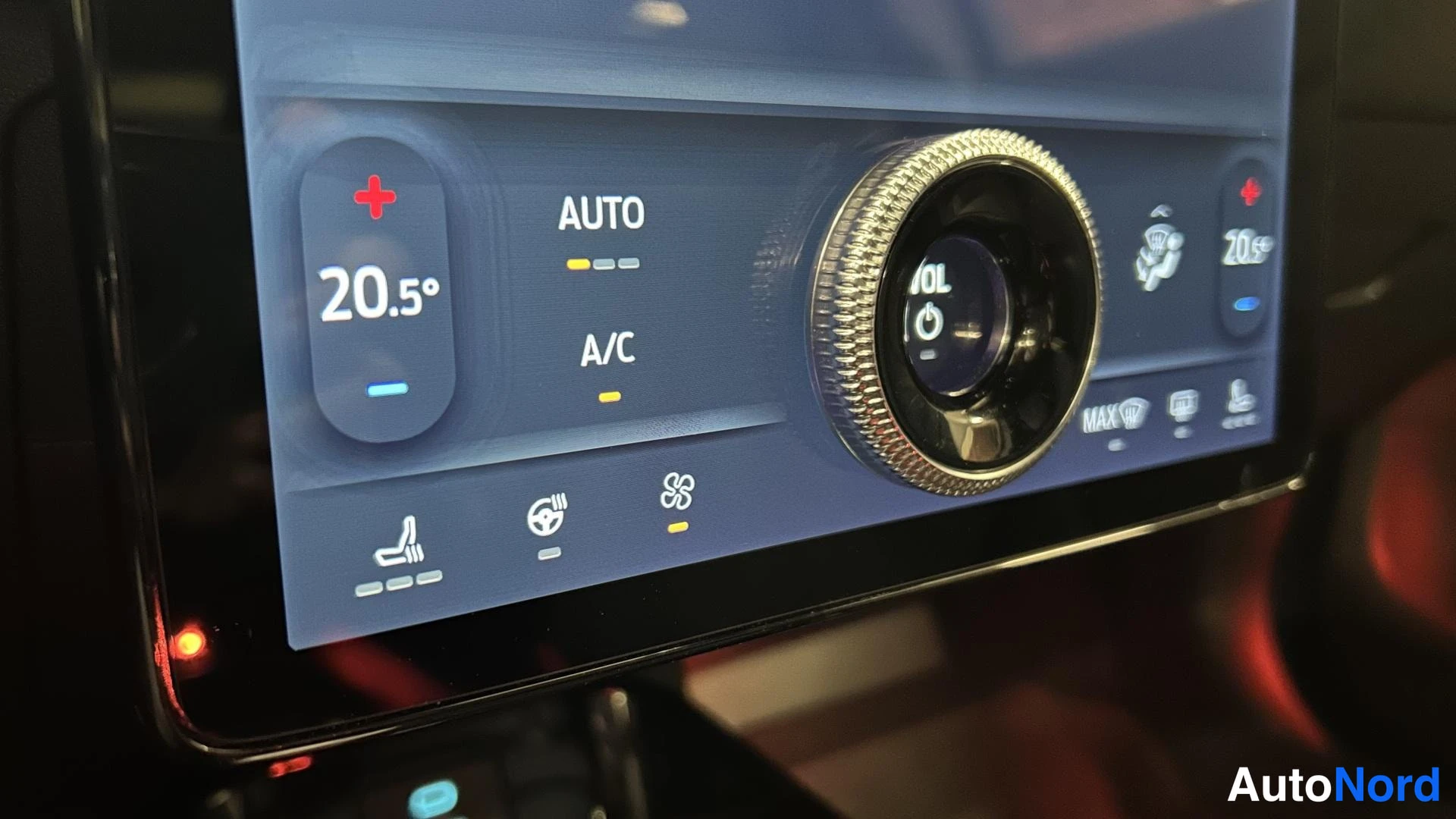 Muu: Lähikuva infotainment-näytön alaosasta: ilmastointiasetukset (AUTO, A/C, 20.5°) ja kierrettävä äänenvoimakkuussäädin.