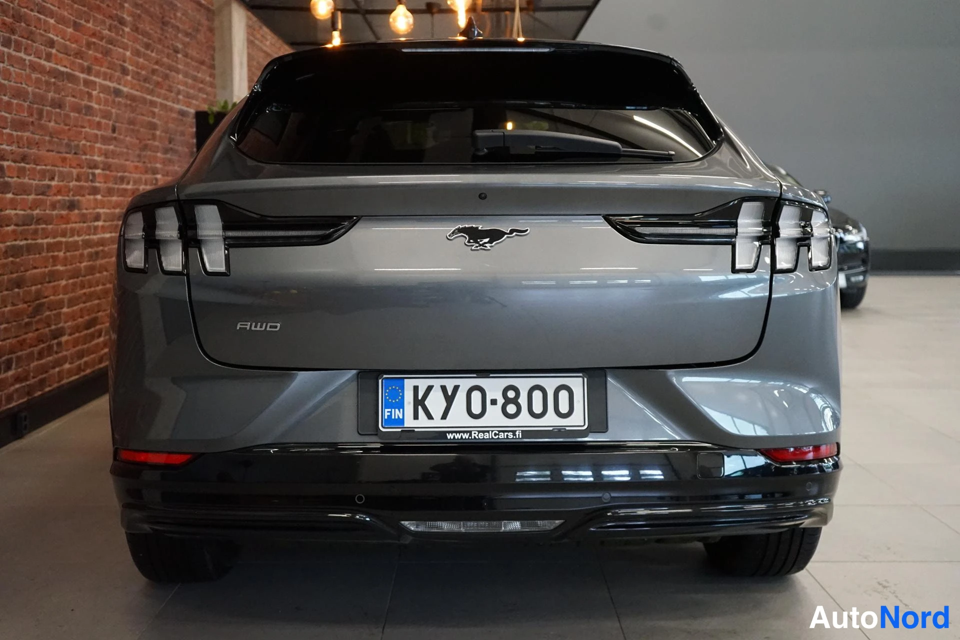 Takaa: Auton takaosa suoraan takaa; harmaan takaluukun keskellä Mustang-merkki, vasemmalla AWD-tunnus ja laatta KY0-800.