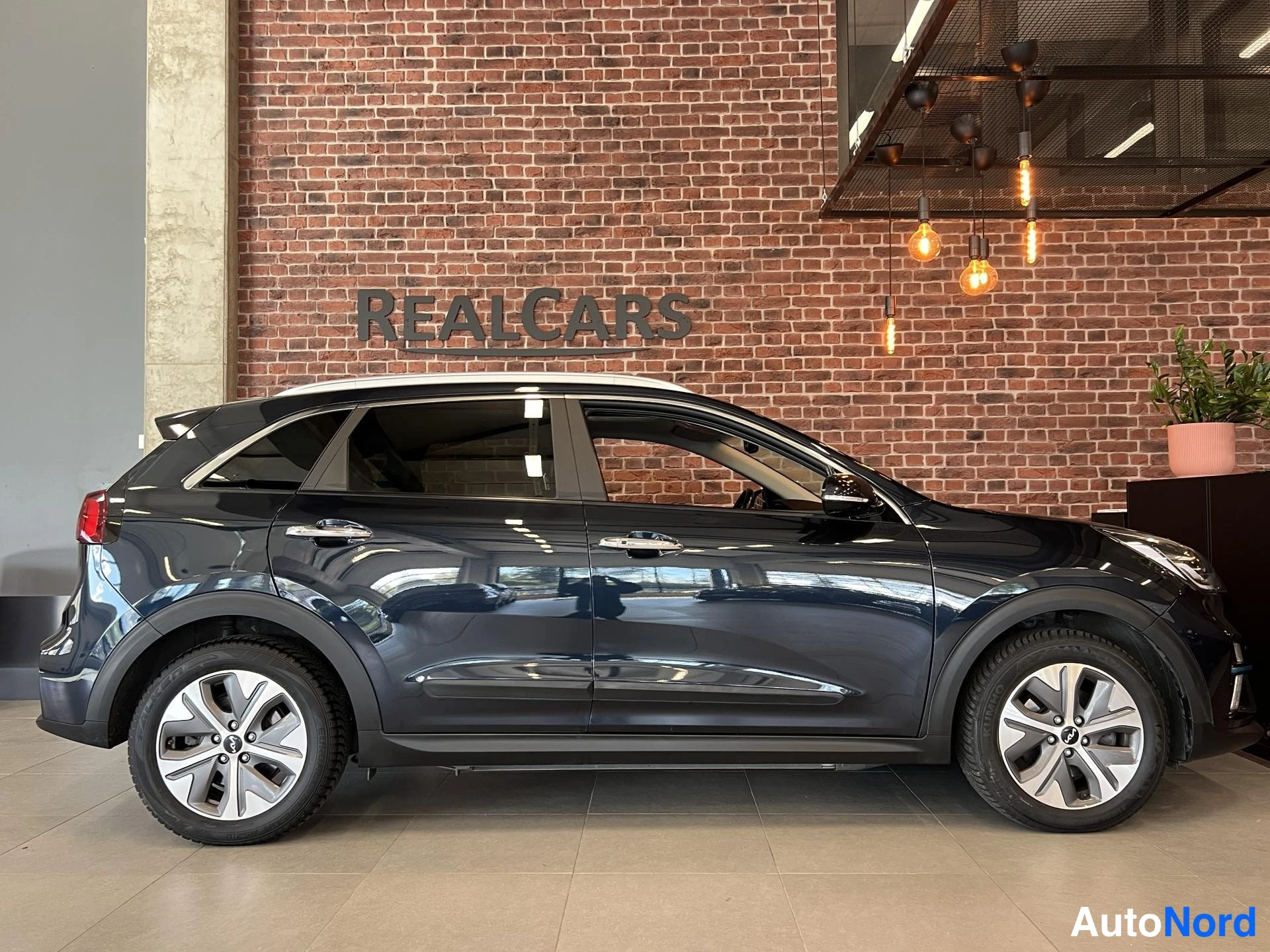 Sivulta: Kia Niro Electric 2022, sivukuva sisätilassa, tummansininen