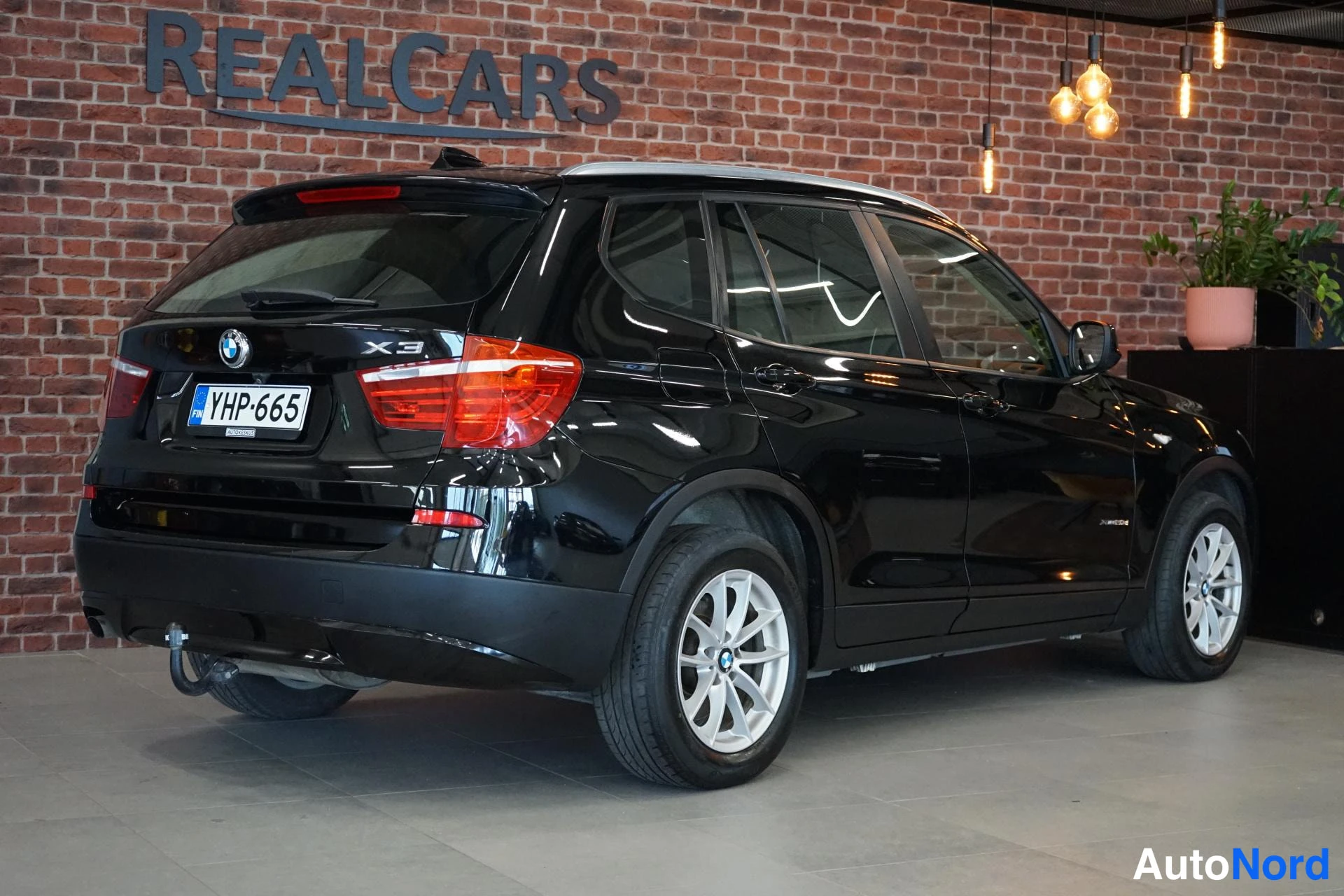 Takaviisto: BMW X3, musta, takaa sivulta kuvattu; perävaunukoukku ja kattokaiteet näkyvissä