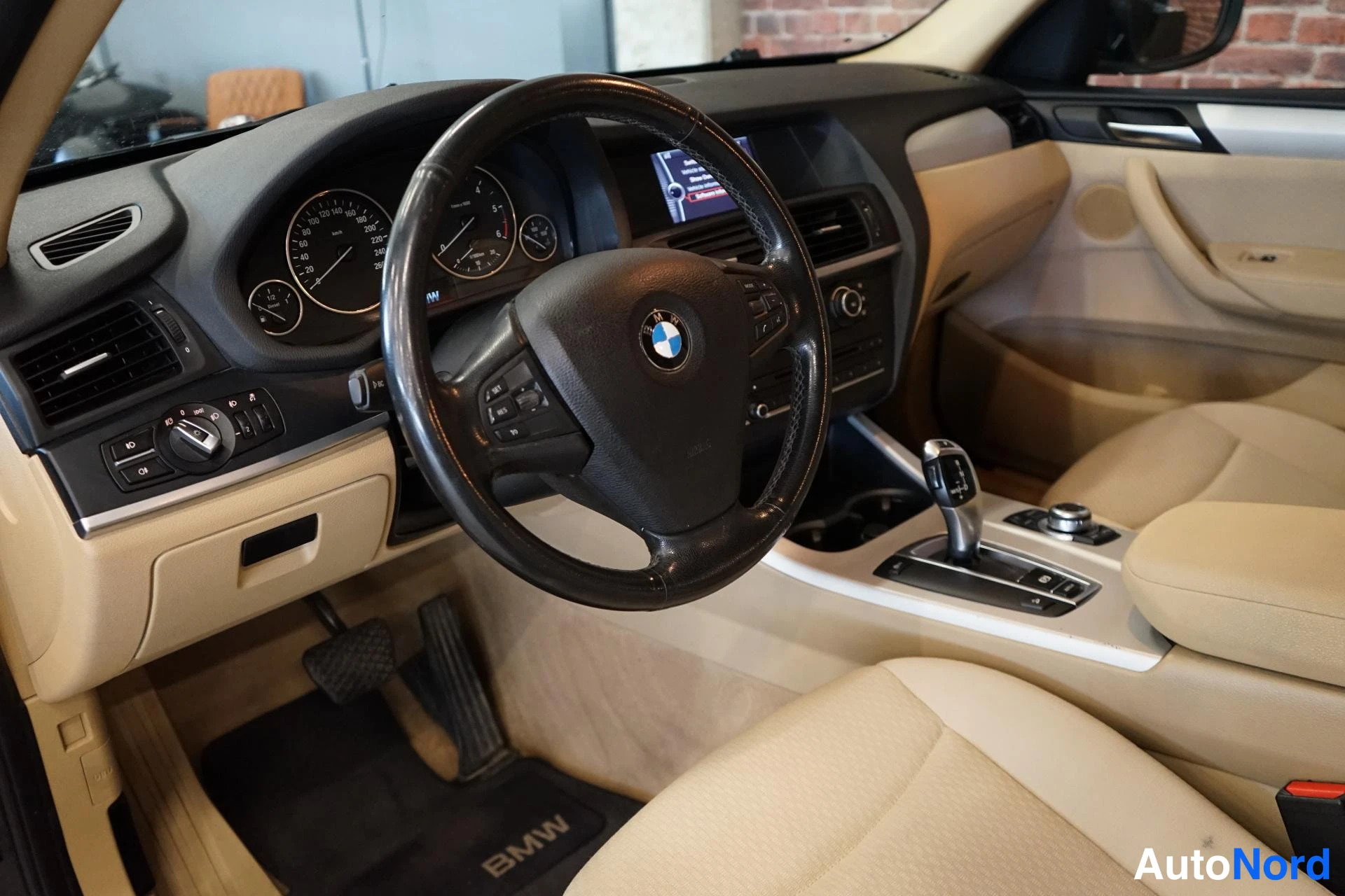 Edestä: Kuljettajan näkökulma: BMW-ohjauspyörä, mittaristo ja ei-toimiva laitteen näyttö.