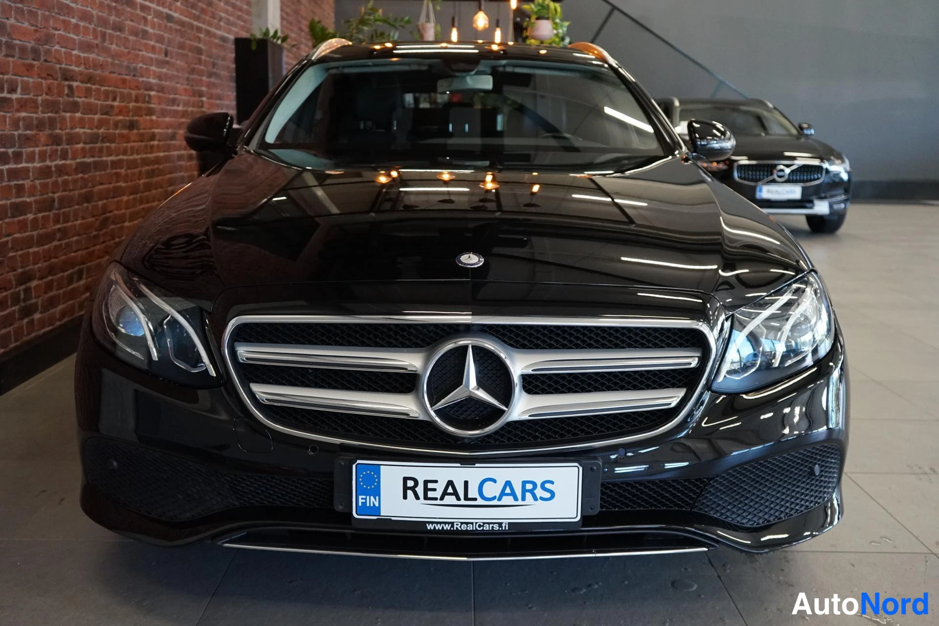 Edestä: Mustan Mercedes-Benzin etunäkymä, näkyvät etugrilli, Mercedes-tähti ja ajovalot