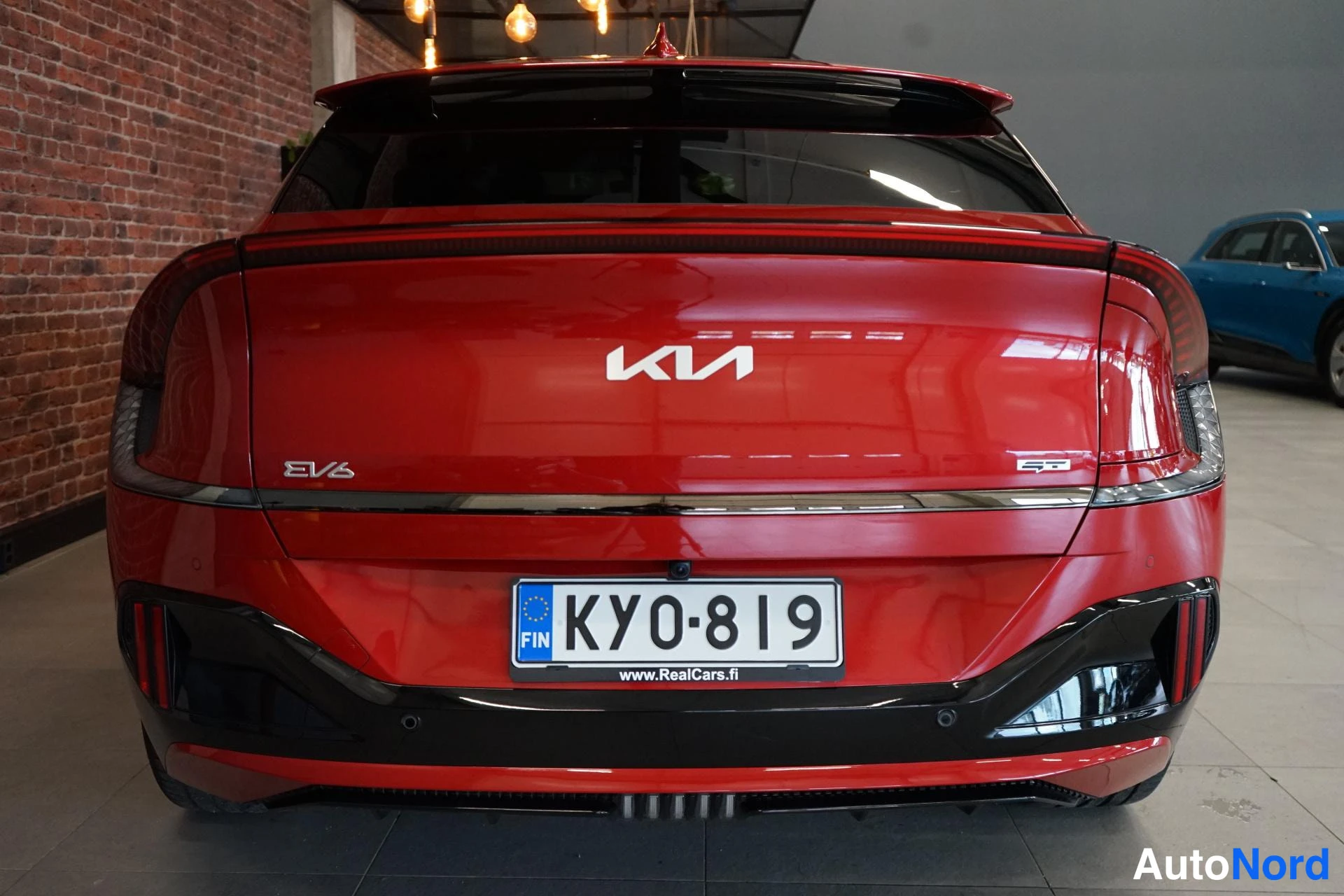 Takaa: Punaisen auton takaosa, KIa-merkki ja EV6-merkki takaluukussa, rekisterikilpi.