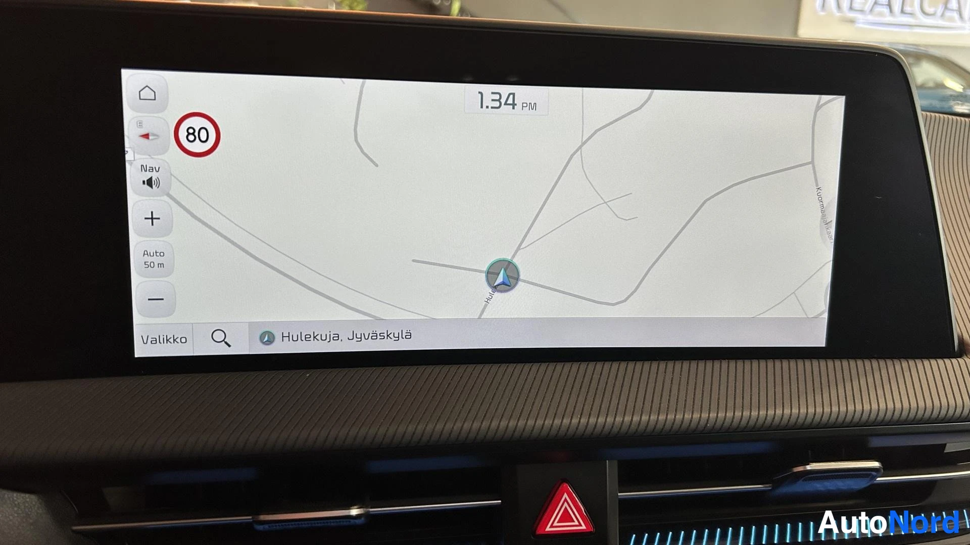 Yksityiskohta: Infotainment-näyttö, jolla karttanavigaatio ja teksti 'Hulekuja, Jyväskylä'.