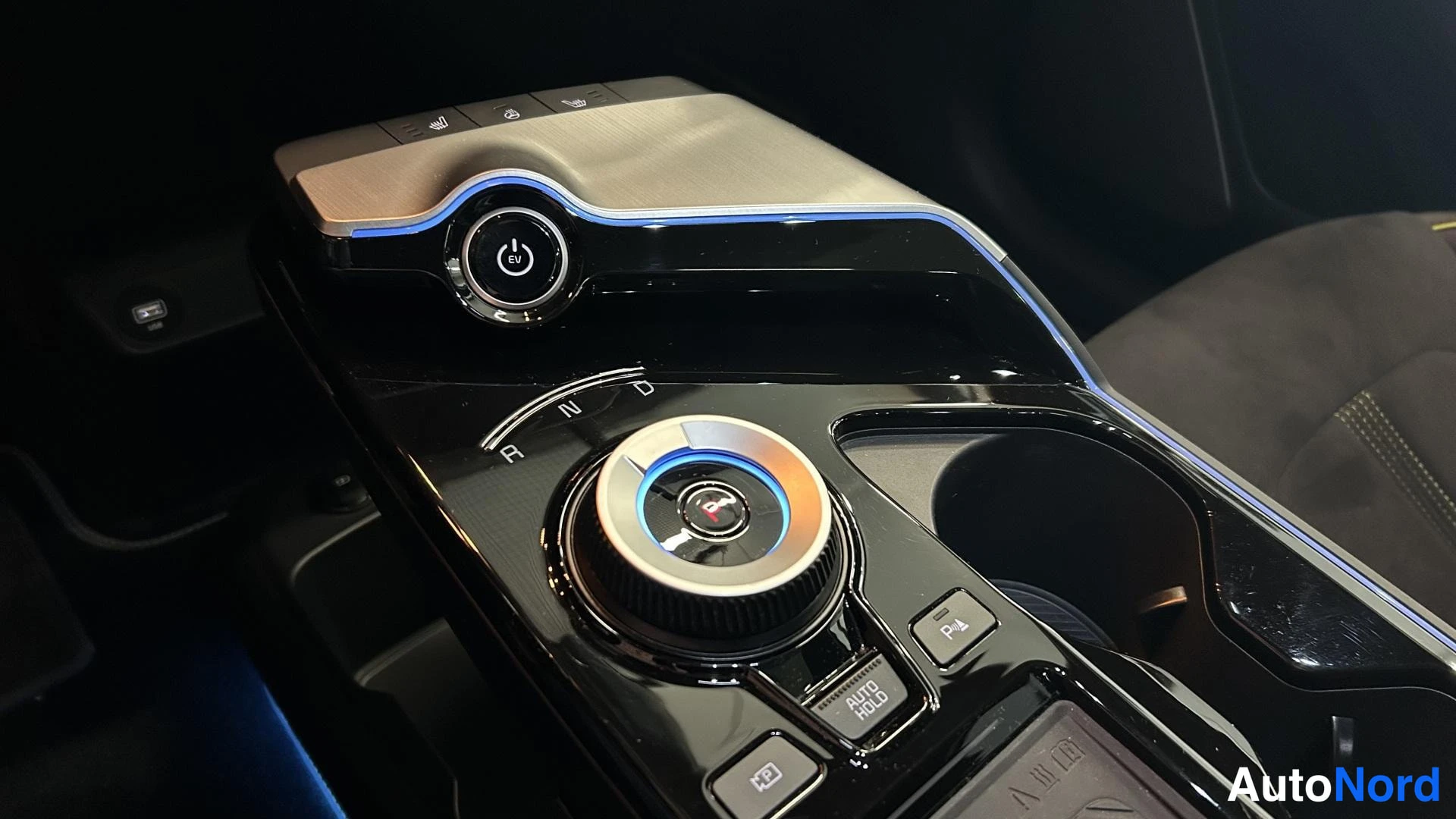Yksityiskohta: Keskitunnelin pyörivä vaihteenvalitsin ja AUTO HOLD -nappi.