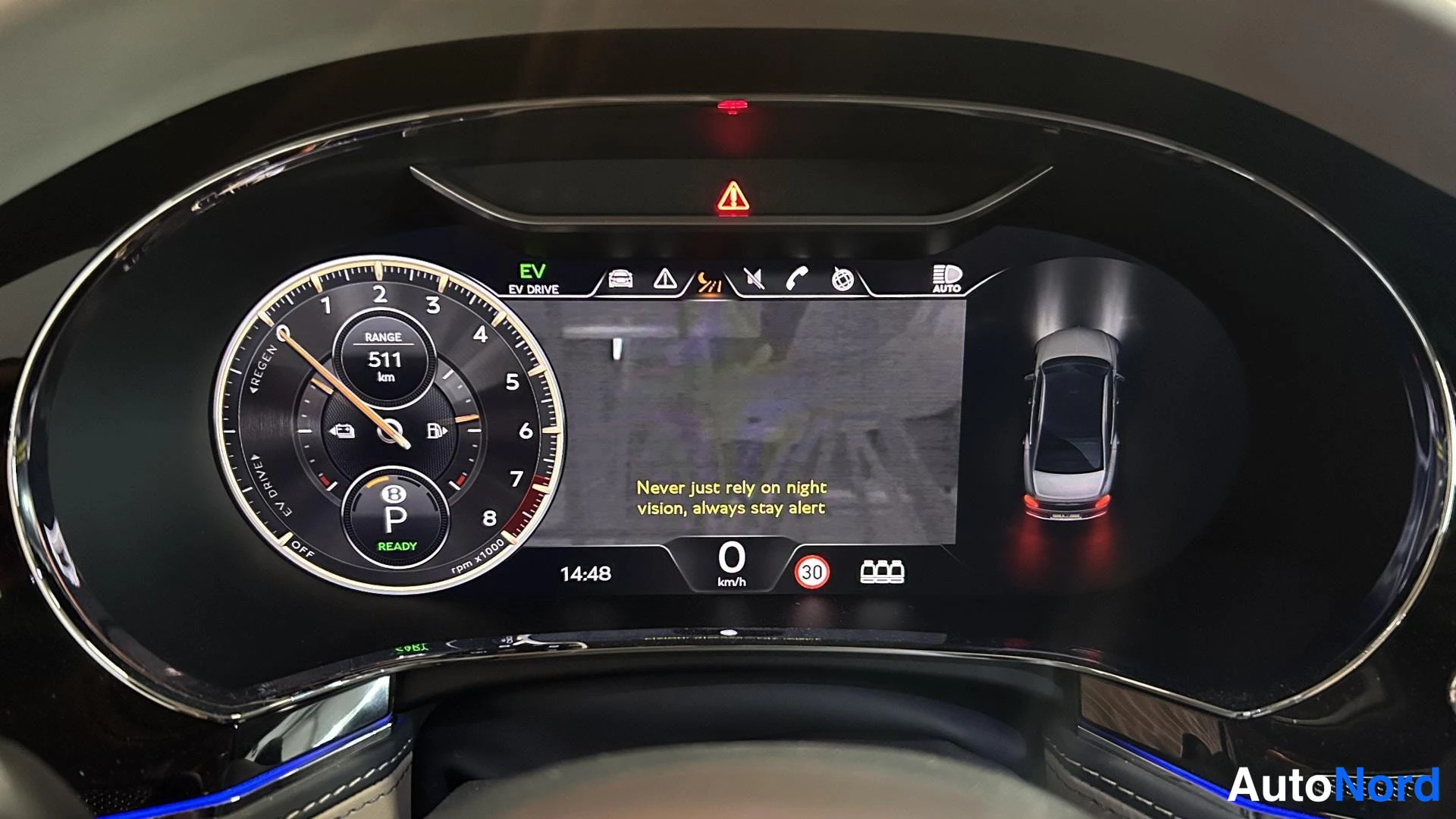 Yksityiskohta: Digitaalinen mittaristo: EV Drive -tila, kantama 511 km, vaijerit N ja P, valmis-merkki, kello 14:48, nopeus 0 km/h, varoitus tekstistä 'Never just rely on nigh