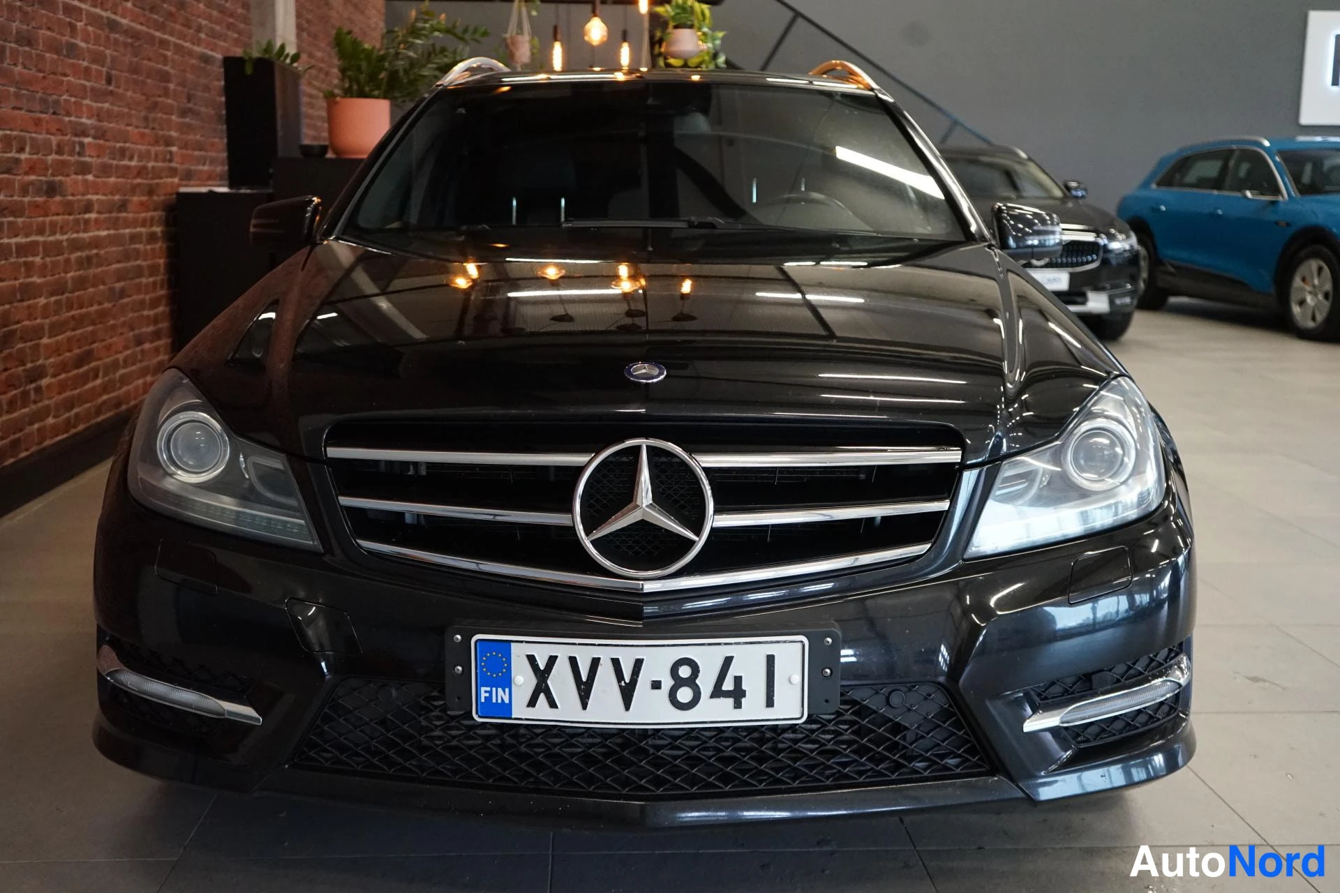Edestä: Mercedes-Benzin musta etupää tässä kuvassa: etusäleikkö Mercedes-tähdellä, sumvalyhdyt ja rekisteritunnus.