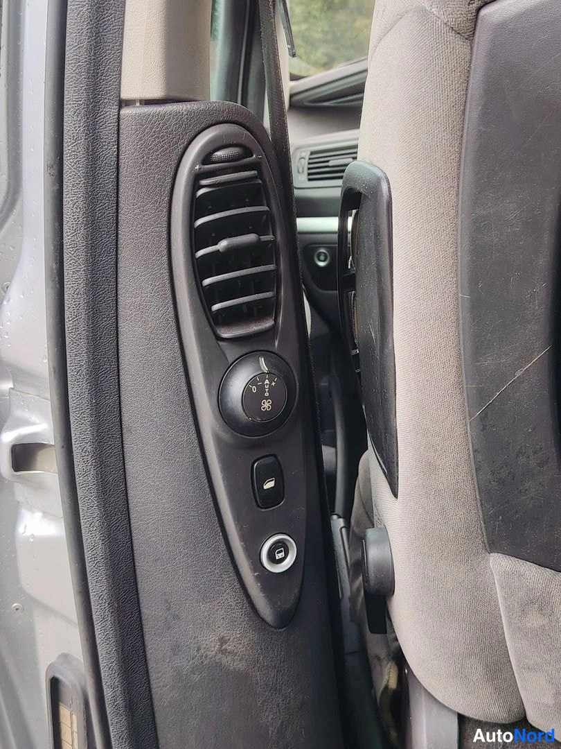 Muu: B-pillar panel with round air vents, rear climate control knob and 12V socket next to a fabric car seat.