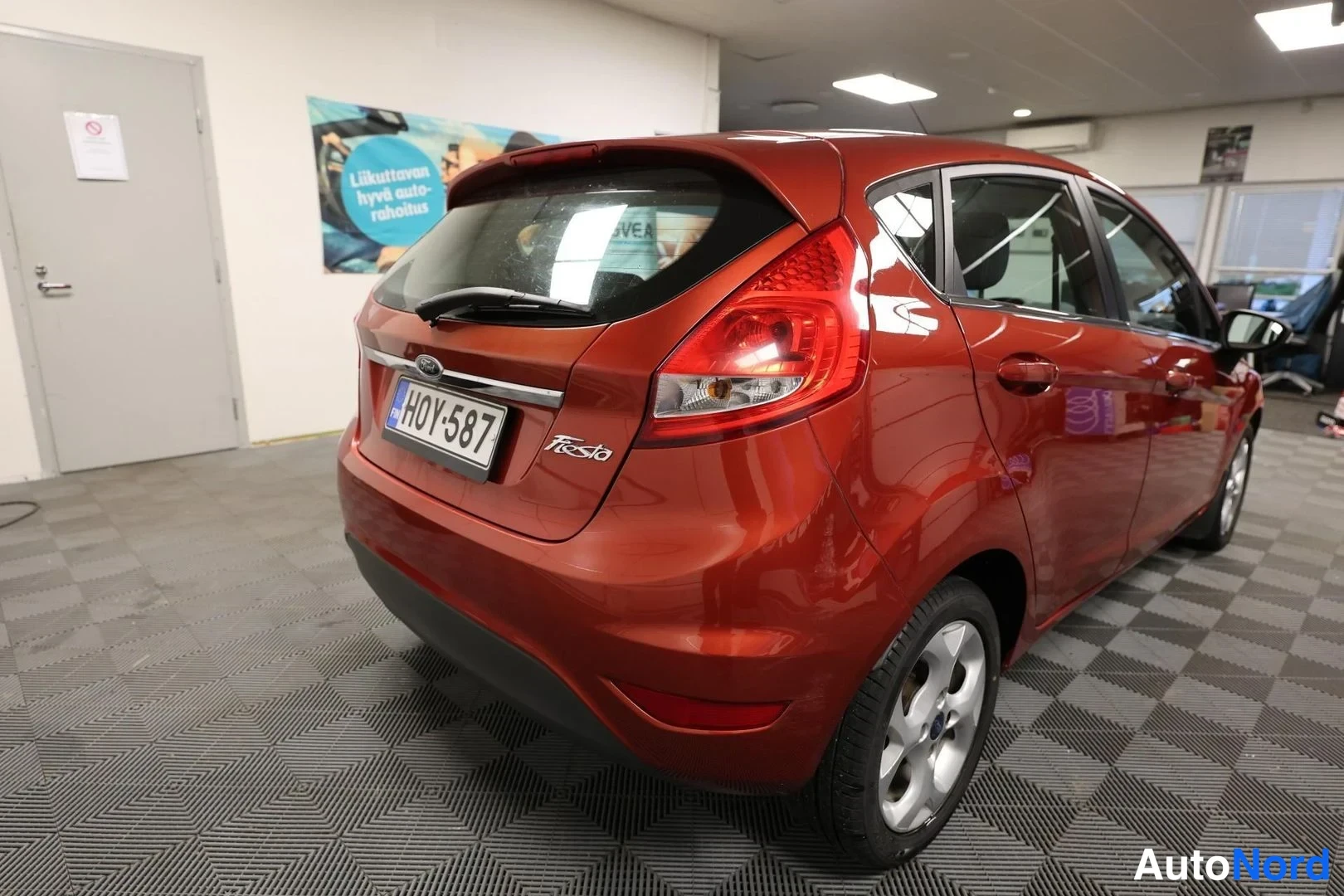 Takaviisto: Punaisenruskean Ford Fiestan takaosa ja vasen sivu kuvattuna vinosti takaa, rekisteritunnus.