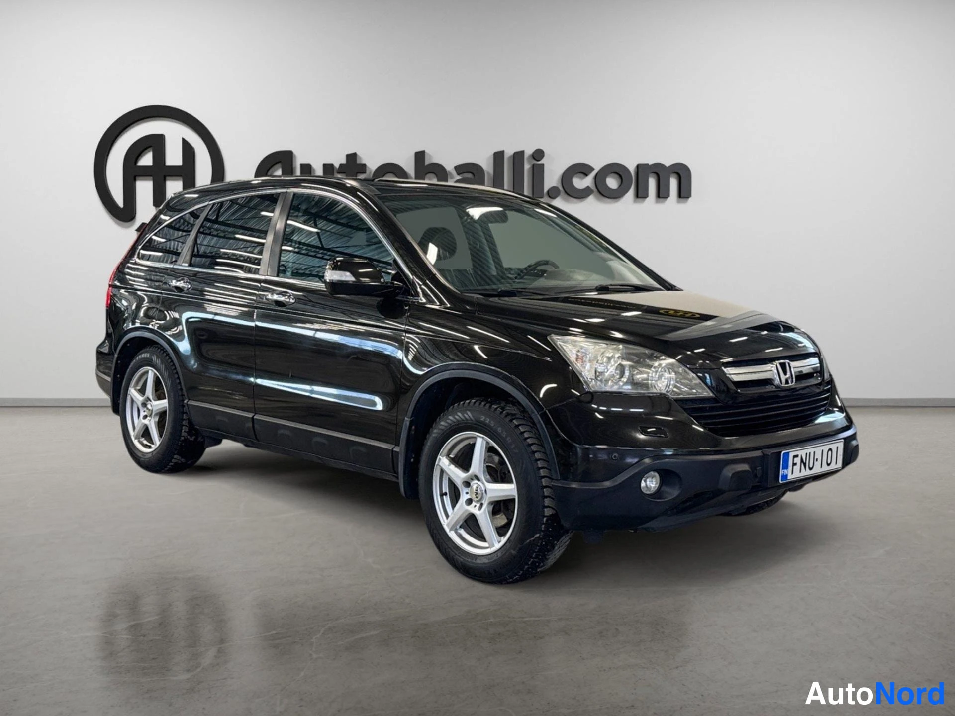 Etuviisto, nokka oikealle: Mustan Honda CR-V:n etukulma, etusäleikkö ja kylki näkyvissä, rekisteritunnus.