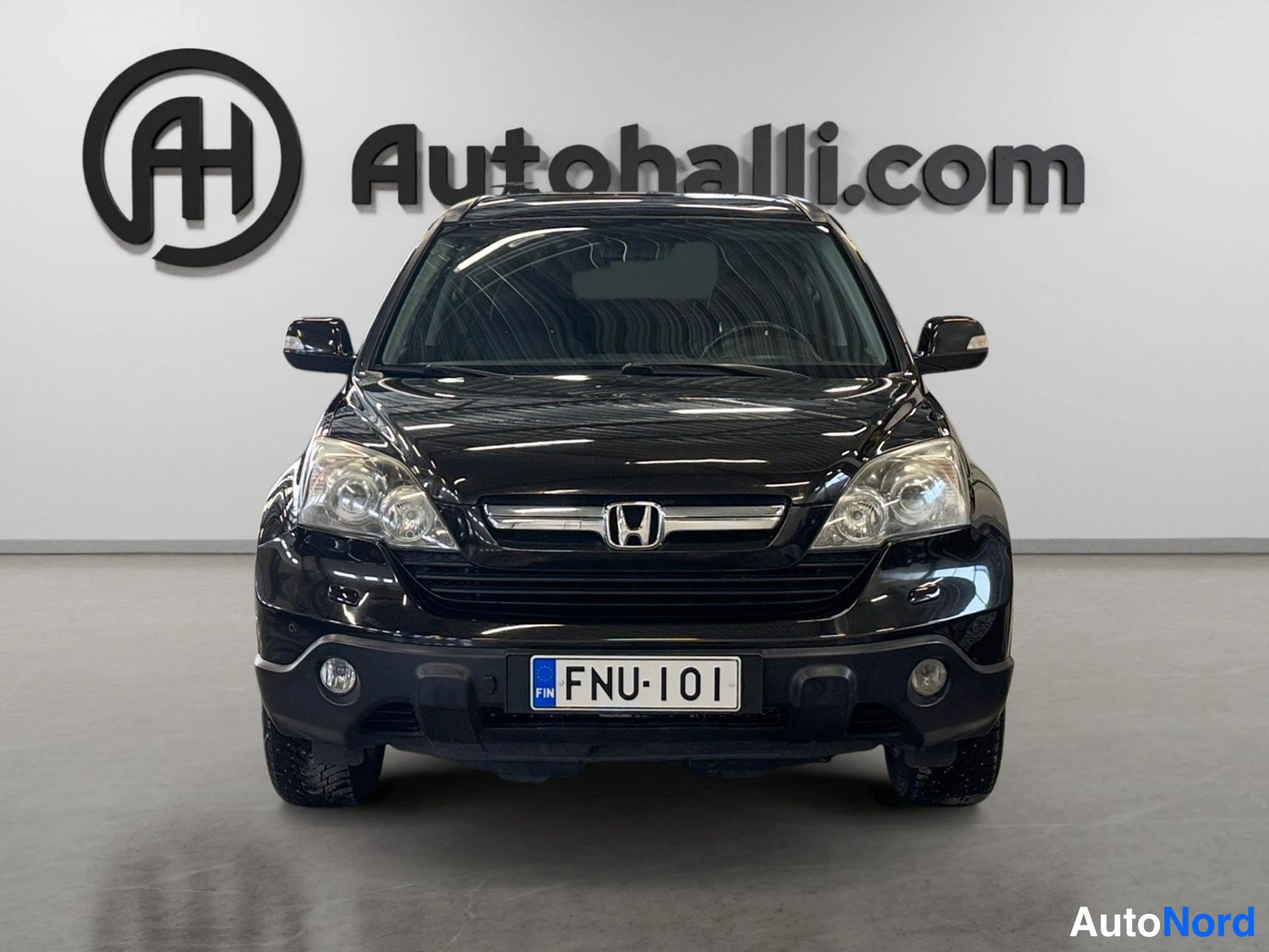 Edestä: Mustan Honda CR-V:n etunäkymä, etusäleikkö ja ajovalot suoraan edestä.