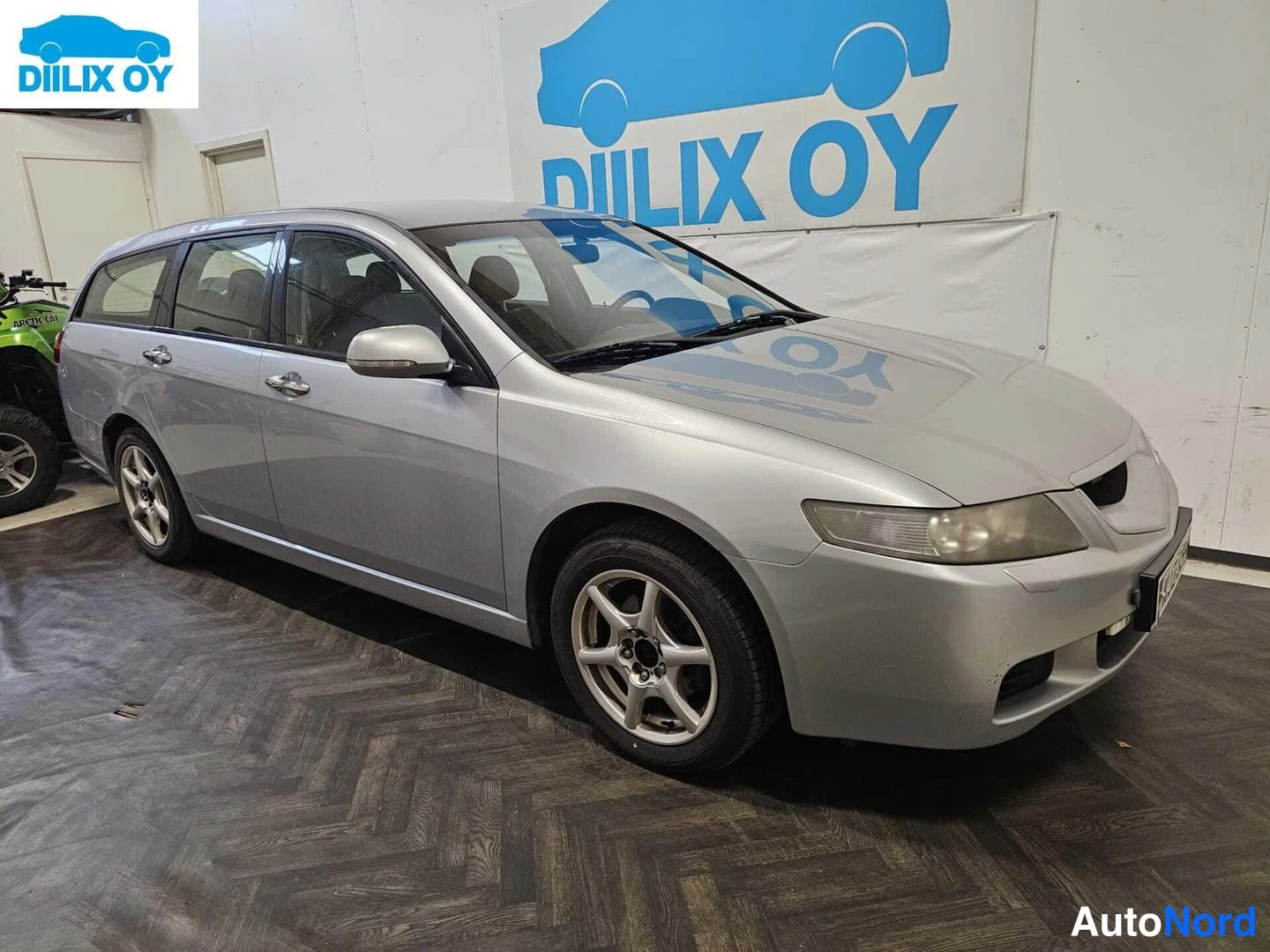 Etuviisto, nokka oikealle: Hopea Honda Accord -farmari etuviistosta sivusuunnassa, keula kuvan oikealla puolella.