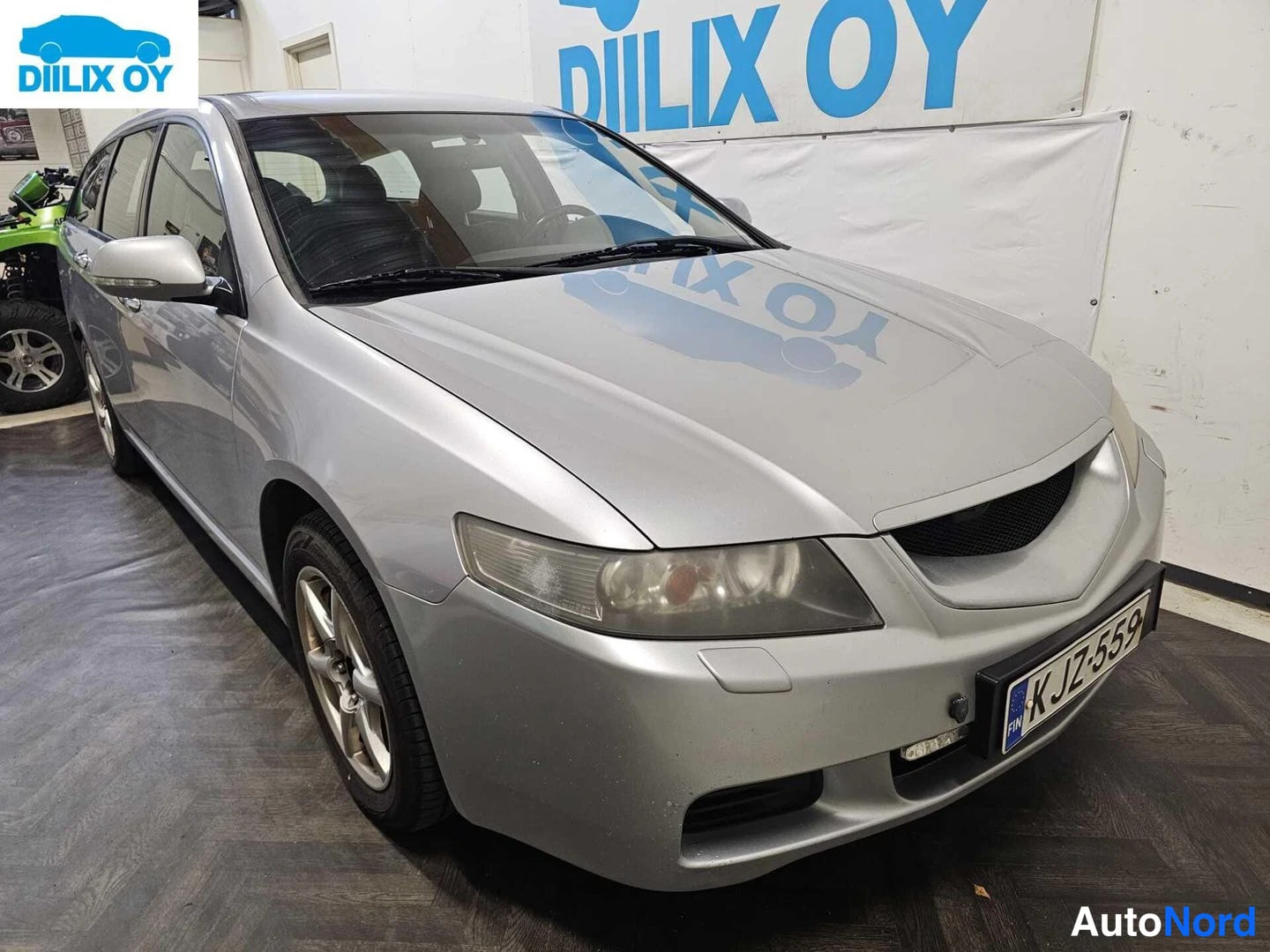 Etuviisto, nokka oikealle: Hopea Honda Accord -farmarin keula etuviistosta, rekisterikilpi.