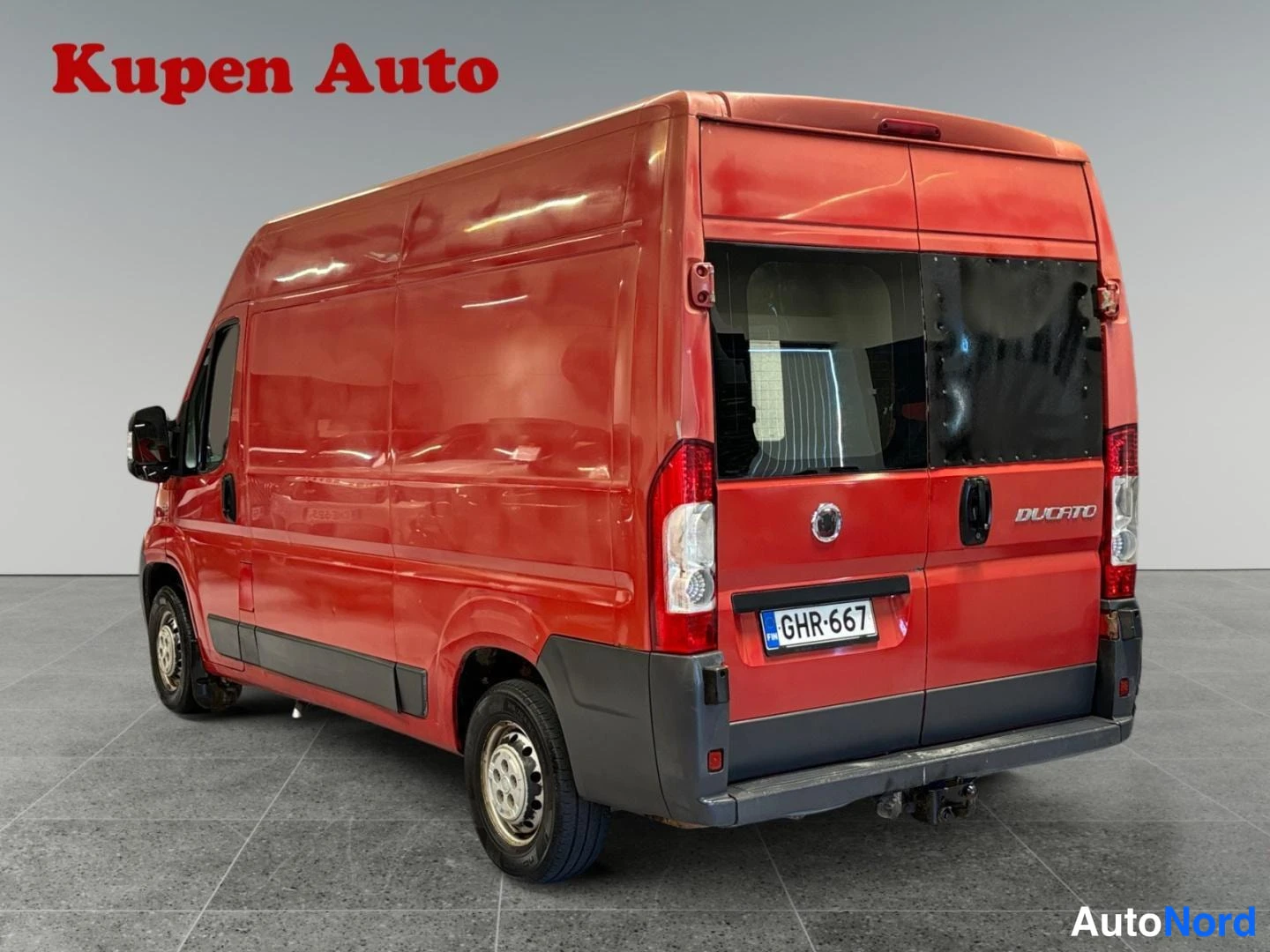 Takaviisto: Punaisen Fiat Ducato -pakettiauton takakulmanäyttö, peräluuku DUCATO-tekstillä ja rekisterikilpi.