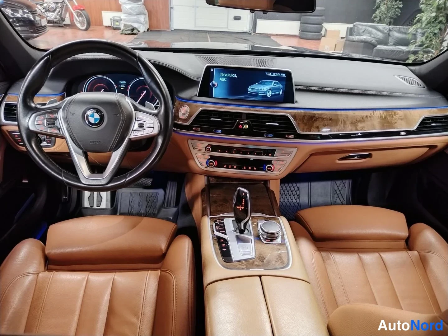 Muu: Auton ohjaamo näkyy kuljettajan istuimelta: BMW-ohjauspyörä, digitaalinen mittaristo, keskikonsolissa vaihteenvalitsin ja iDrive-ohjain, ruskeat nahkaistuimet s
