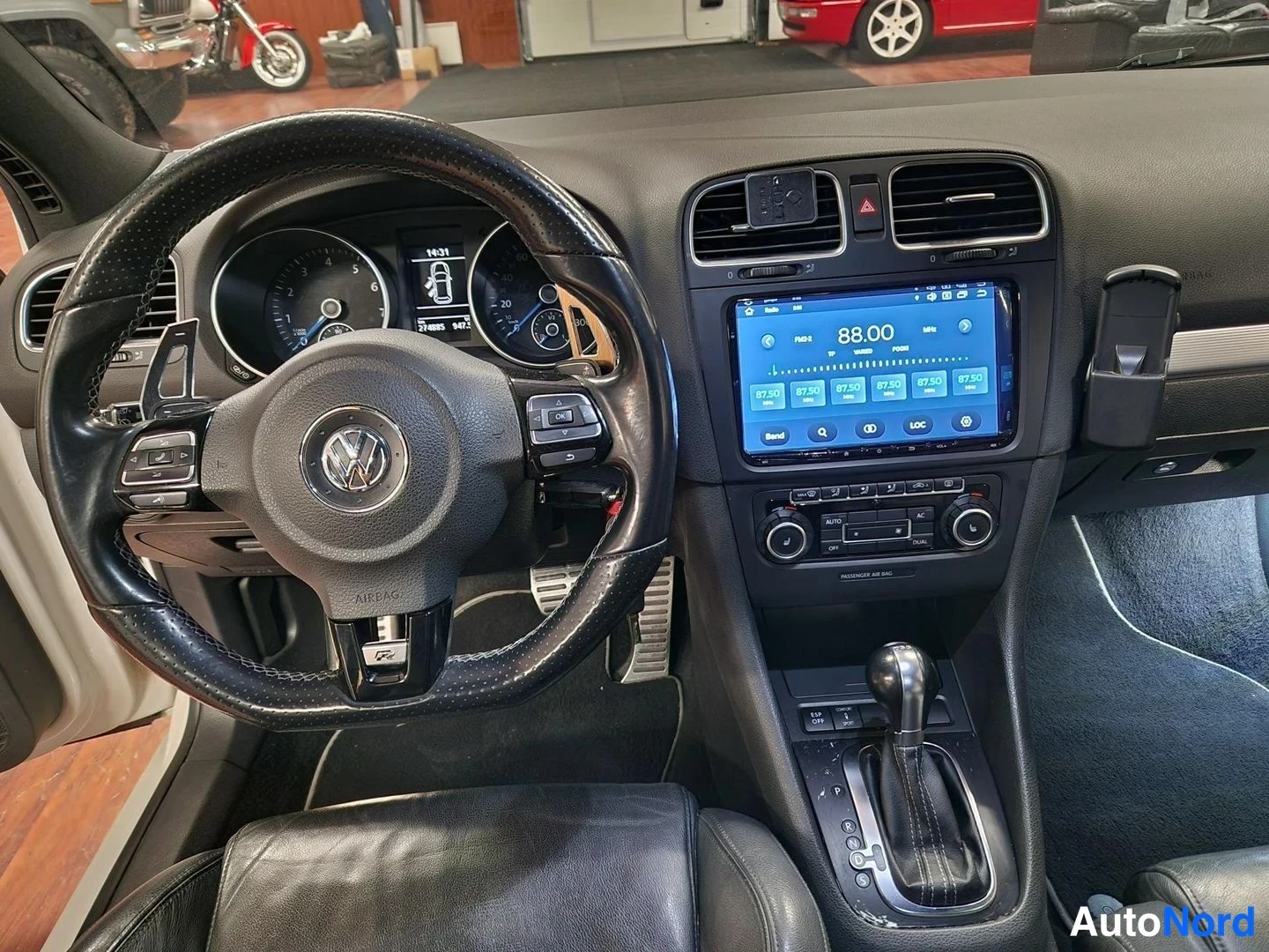 Muu: Auton ohjaamo vasemmalta: VW-merkkinen ohjauspyörä, mittaristo näyttää 1431 km/j, kojelaudassa kosketusnäyttö radiovastaanotolla 88.00 MHz, DSG-vaihtaja ja manu