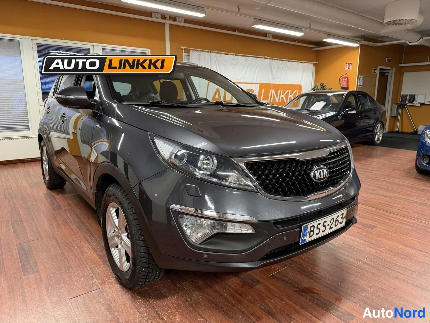 Etuviisto, nokka oikealle: Tummanharmaa Kia Sportage etukulmasta, rekisteritunnus