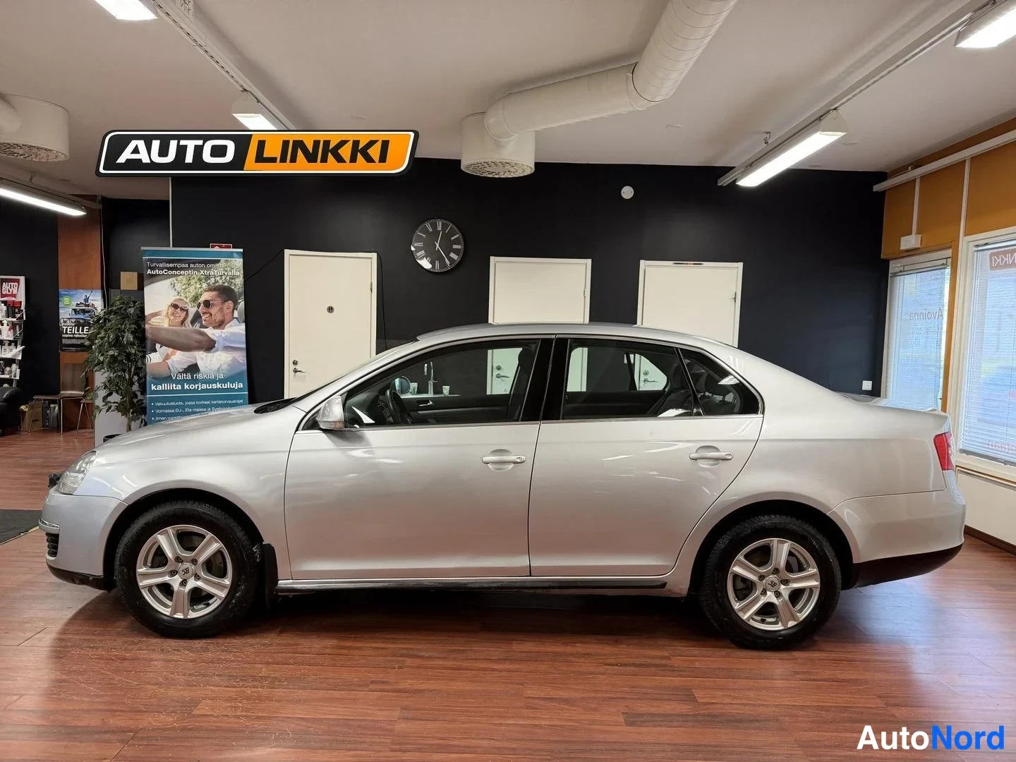 Sivulta: Hopeanharmaan Volkswagen Jetta -sedanin vasen kylki sivusta sisätiloissa.