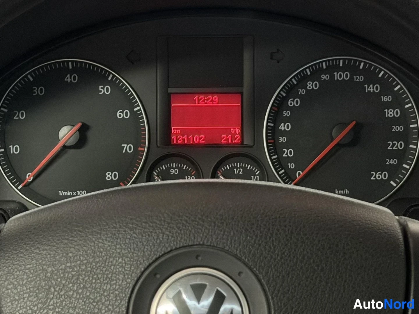 Muu: Kojelaudan mittaristo: nopeusmittari asteikolla 0–260 km/h, kierroslukumittari ja punainen näyttö, jossa lukee 12:29 ja 131102 km.