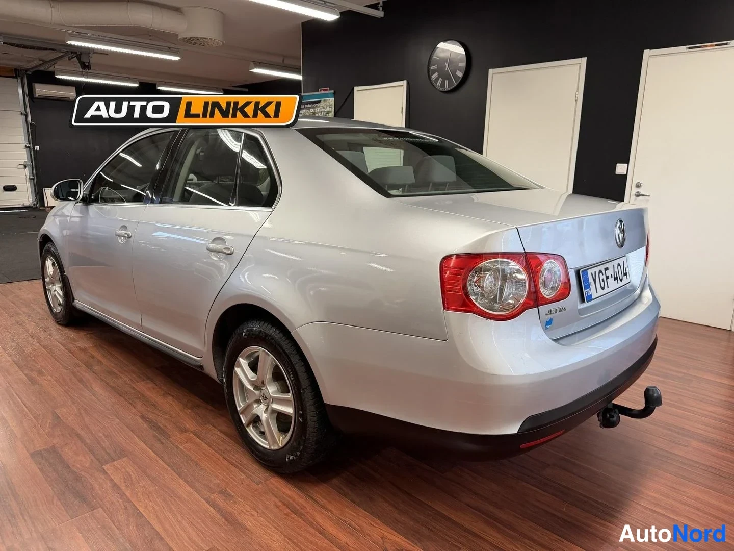 Takaviisto: Hopeanharmaa Volkswagen Jetta -sedan takakulmasta, perä oikealla, savuhella kiinnitetty takaan.