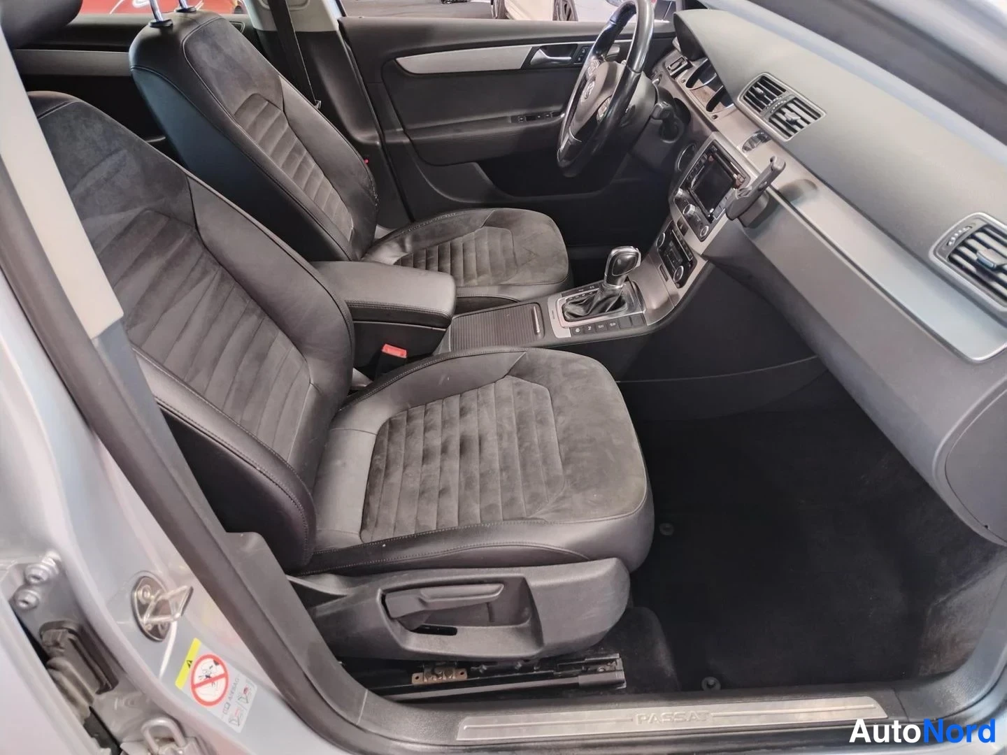 Edestä: Volkswagen Passat Variantin etuistuimet ja kojelauta mustalla sisustuksella.