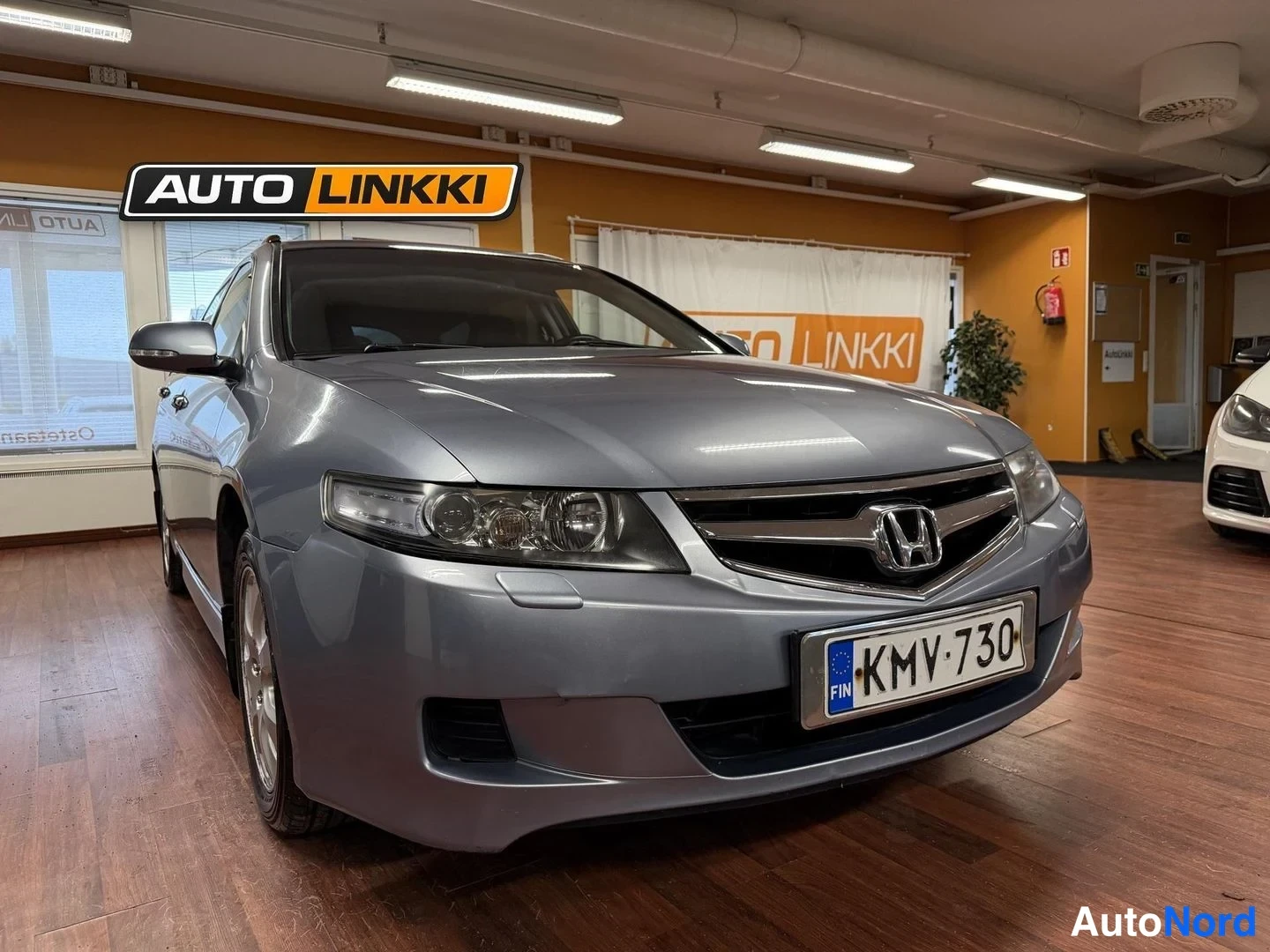 Etuviisto, nokka oikealle: Honda Accord Tourer -farmarin keula nokka oikealle, etusäleikkö ja H-merkki näkyvällä, rekisterikilpi