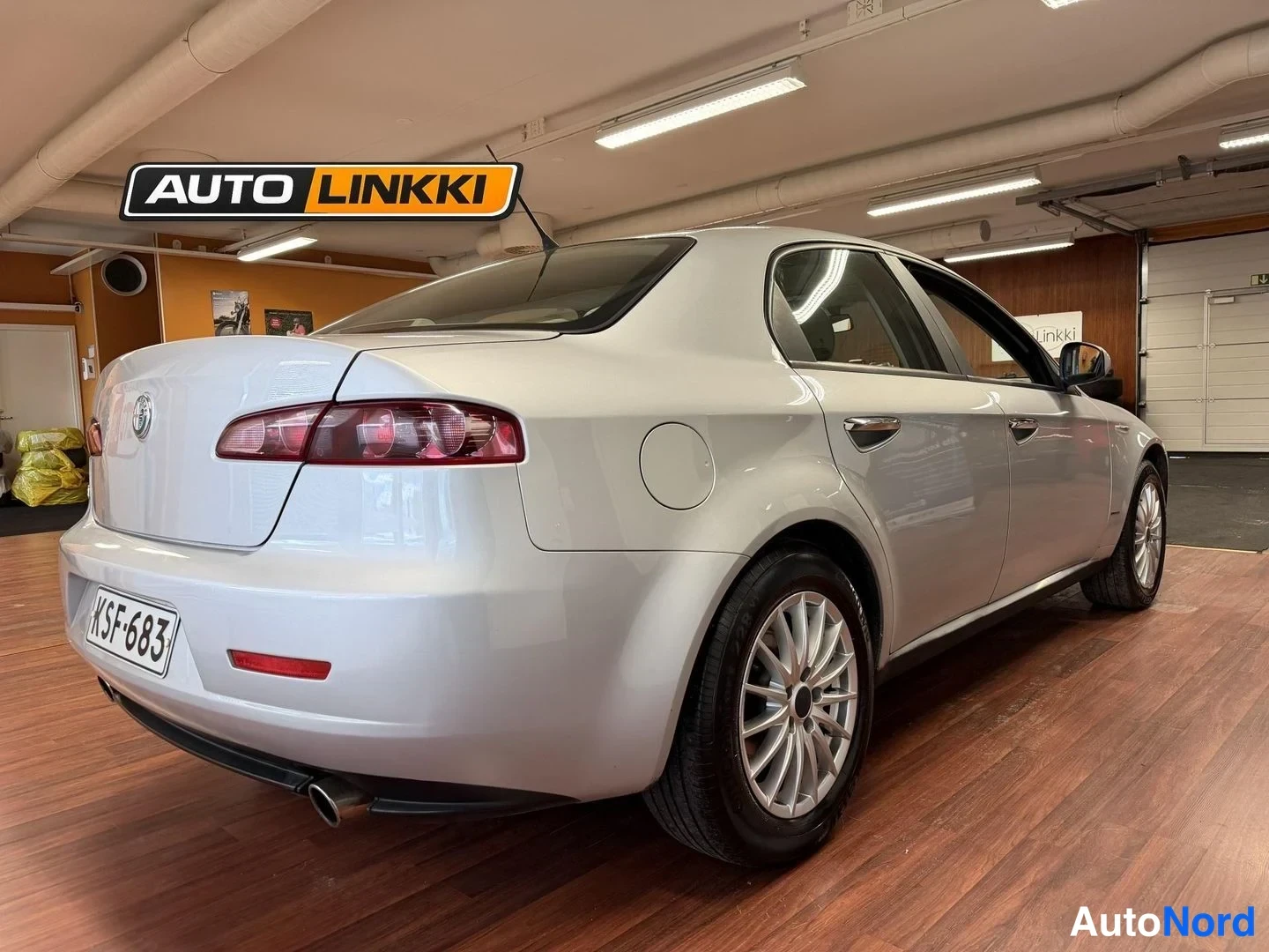 Takaviisto: Alfa Romeo 159 -sedan takakulma sisätiloissa, takavalo ja pakoputki näkyvissä.