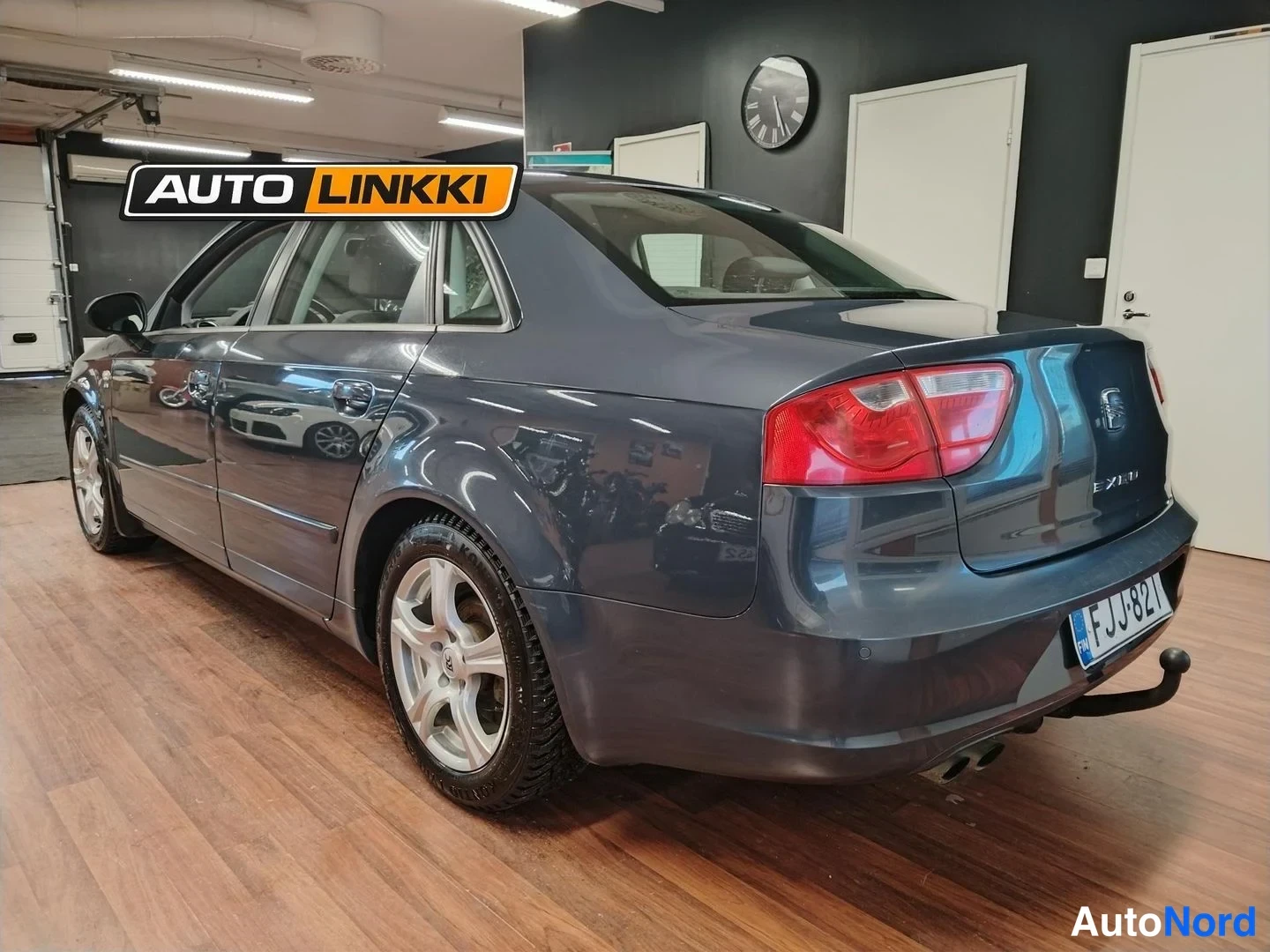Takaviisto: Tummanharmaa Seat Exeo -sedan takakulmassa, takavalo ja rekisterikilpi näkyvissä.