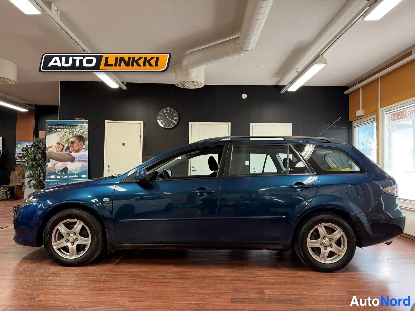 Sivulta: Sininen Mazda 6 -farmari sivulta kuvattuna sisätiloissa.
