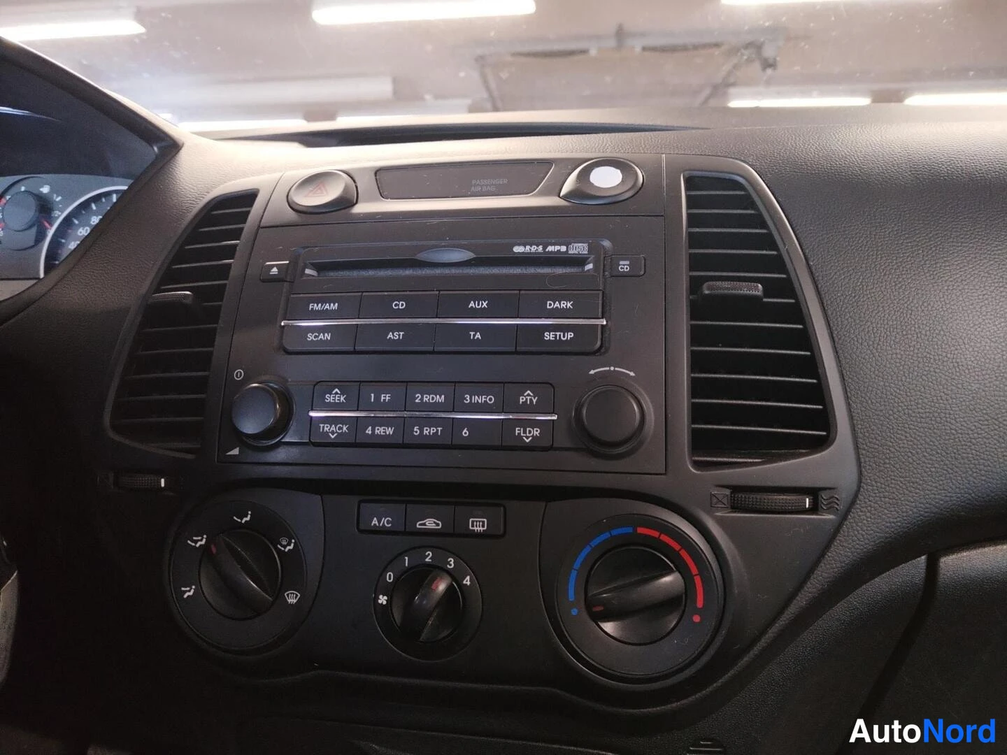Muu: Hyundai i20:n keskikonsolin radio ja ilmastointisäätimet lähikuvassa; radiossa CD-, AUX- ja MP3-toiminnot.