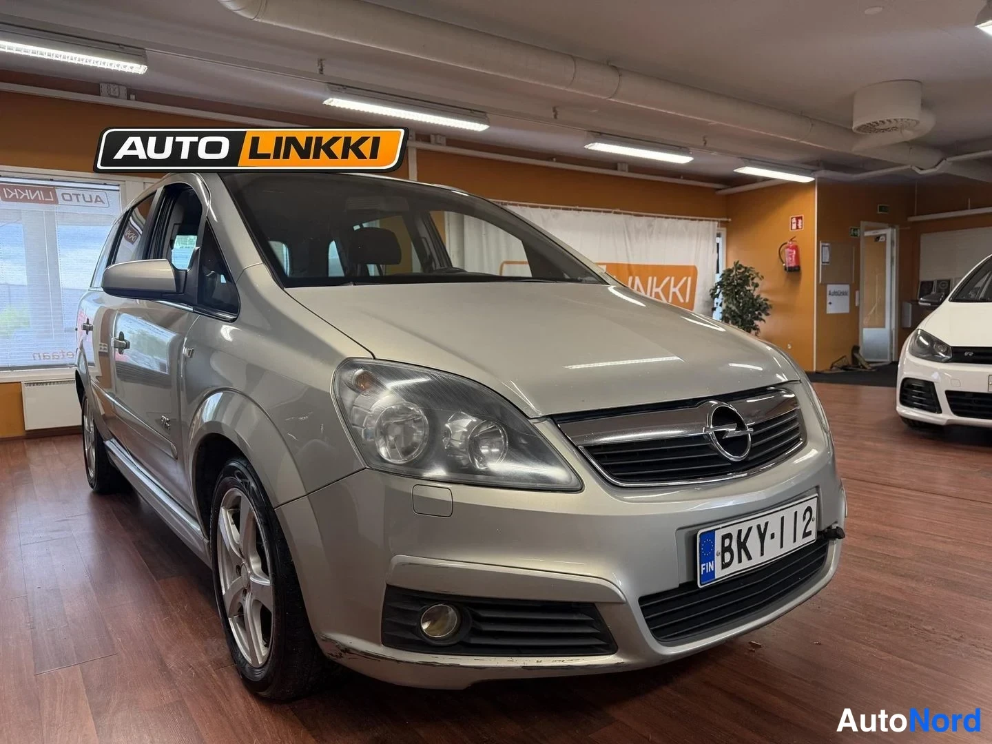 Etuviisto, nokka oikealle: Auton keula ja vasen sivu kuvattuna autonäyttelytilassa; rekisterikilpi.
