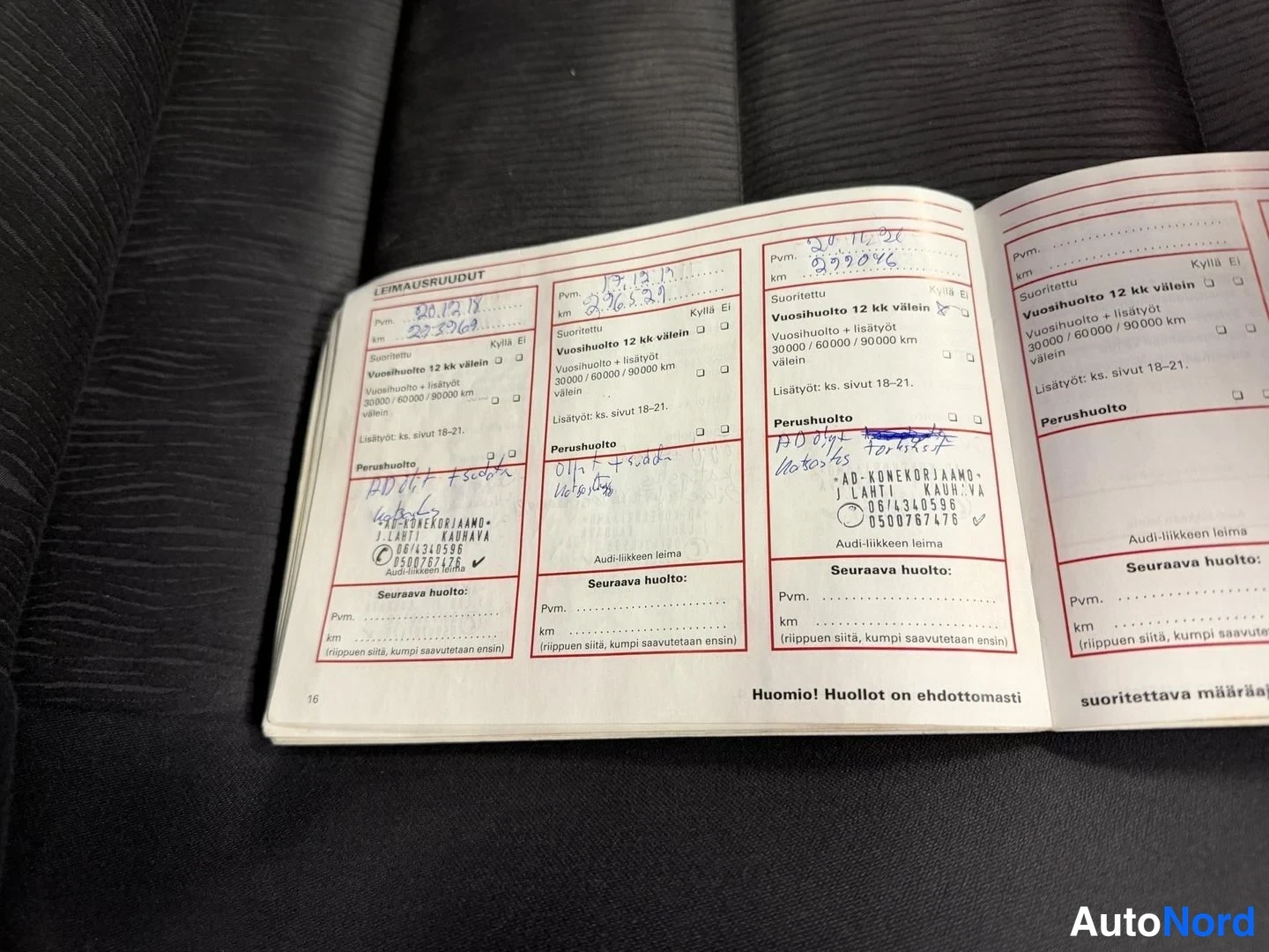 Asiakirja: Avattu huoltokirja, jossa leimattuja vuosihuolto-rivejä, käsinkirjoitettuja päivämääriä ja km-lukuja sekä Auto-Konekorjaamo J Lahti Kauhava -leimoja.