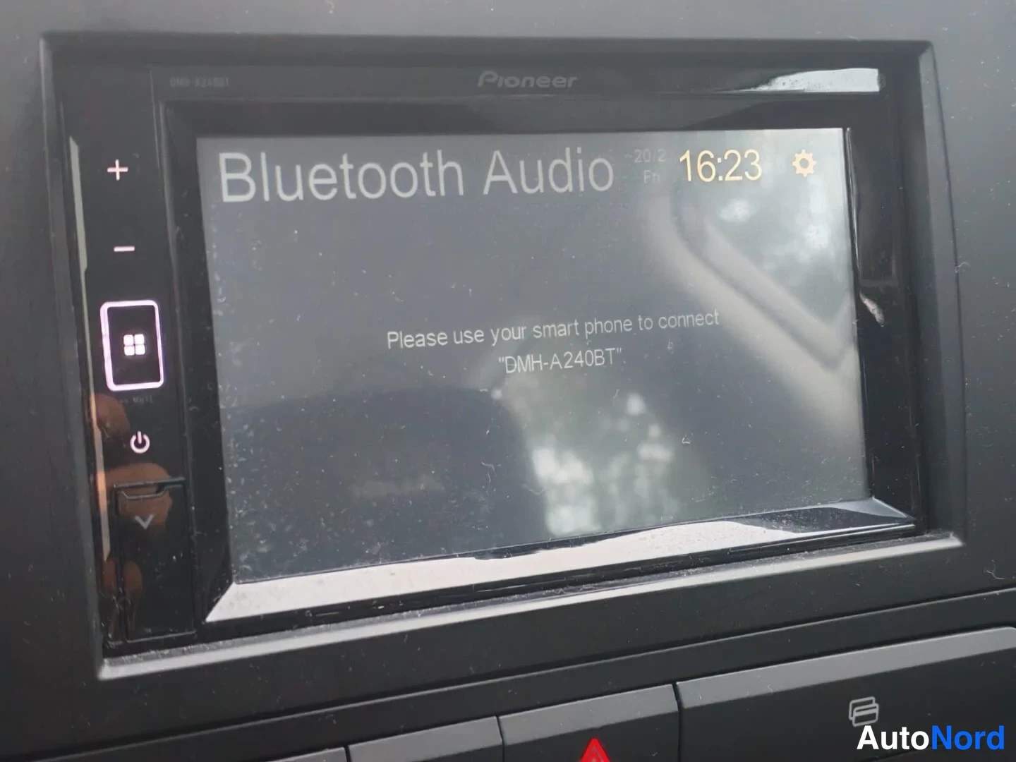 Yksityiskohta: Close-up of Pioneer car infotainment screen showing Bluetooth Audio connection prompt with model DMH-A240BT.
