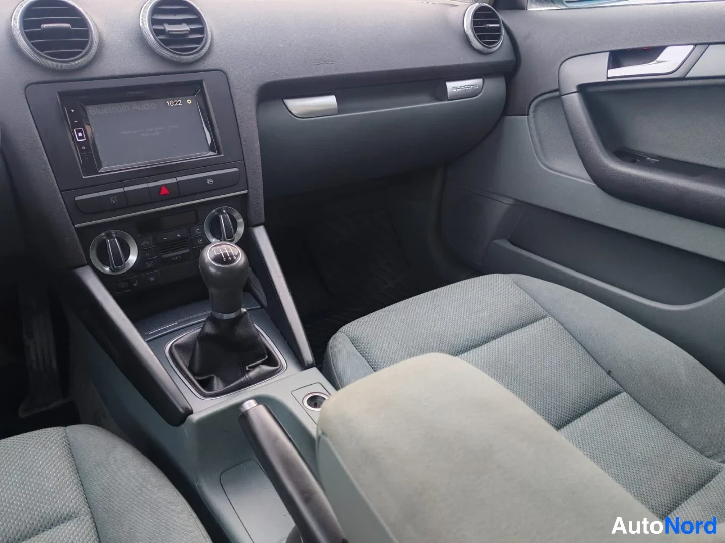 Muu: Audi A3:n etumatkustamo: käsivalintainen vaihteenkeila, radio, ilmastointilaitteiden säätimet ja kaksi etuistuinta.