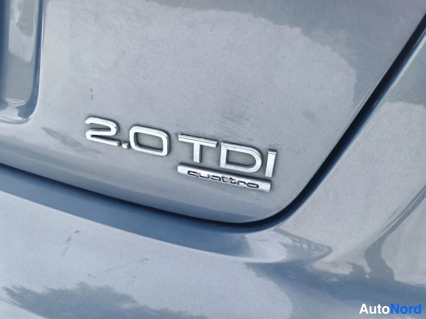 Takaa: Lähikuva Auton takapaneelin metallimerkinnästä: 2.0 TDI ja quattro.