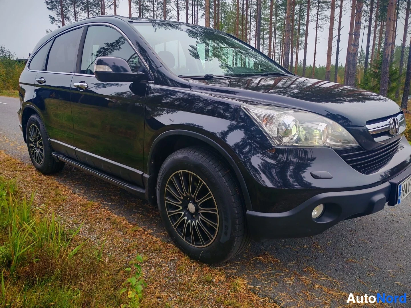 Etuviisto, nokka vasemmalle: Musta Honda CR-V nelikulma-ajoneuvo etu- ja sivunäkökulmasta, metallivalkoiset kevytmetallivanteet näkyvissä