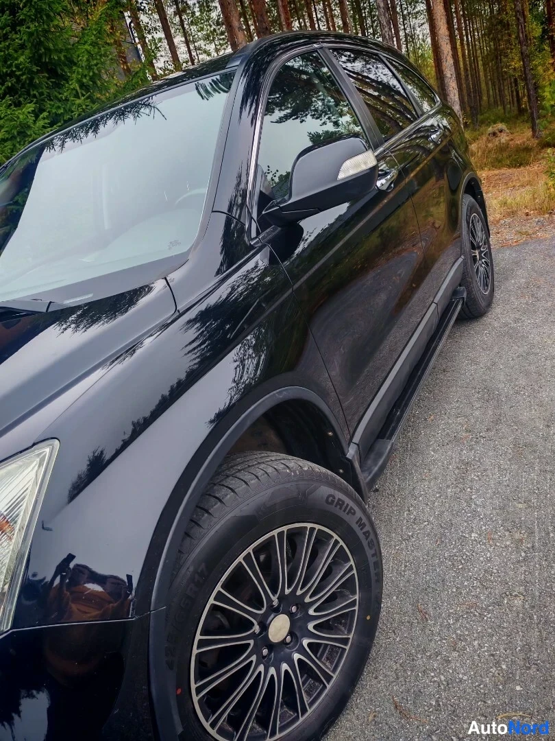 Sivulta: Mustan Honda CR-V:n kylki sivulta kuvattuna, edessä kevytmetallivanne.
