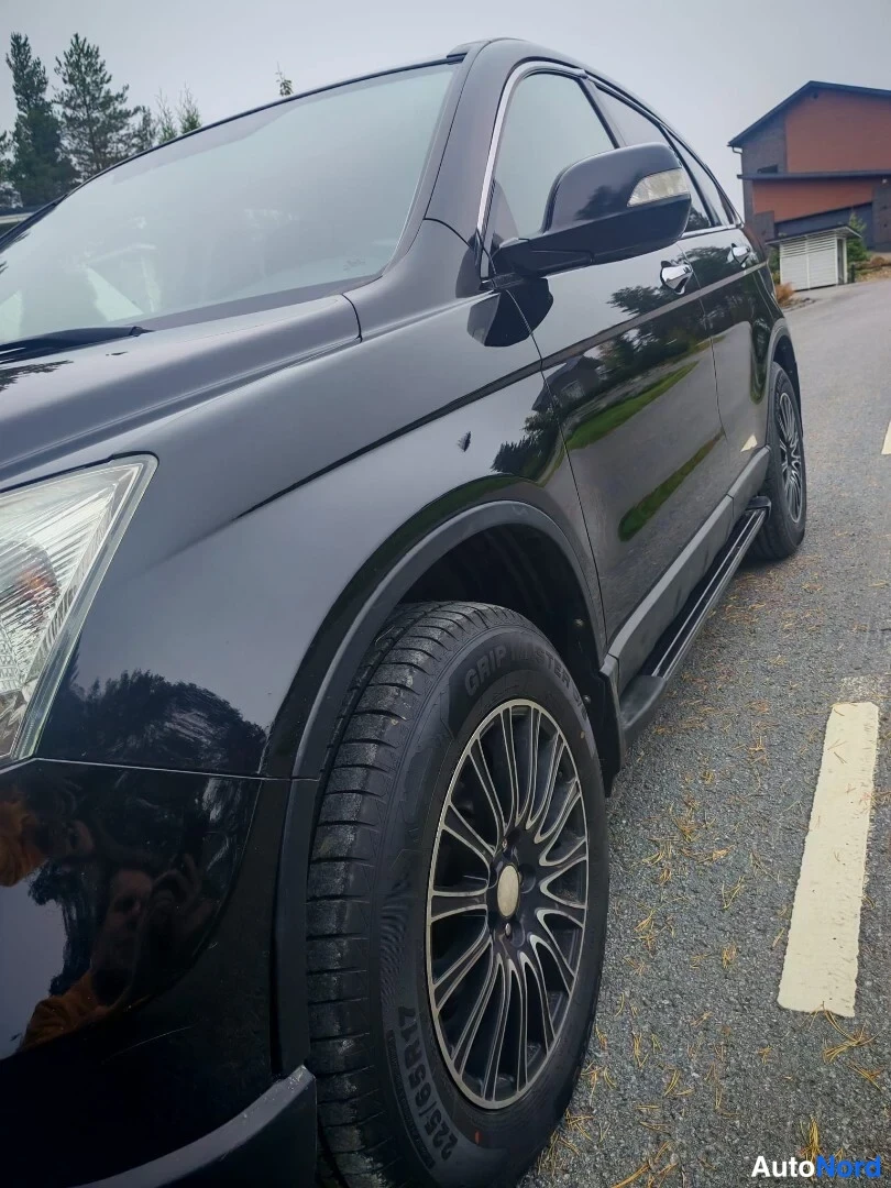 Sivulta: Mustan Honda CR-V:n etusivu lähikuvassa: kylki, etupyörä ja sivulankku näkyvät tiivissä kulmassa.