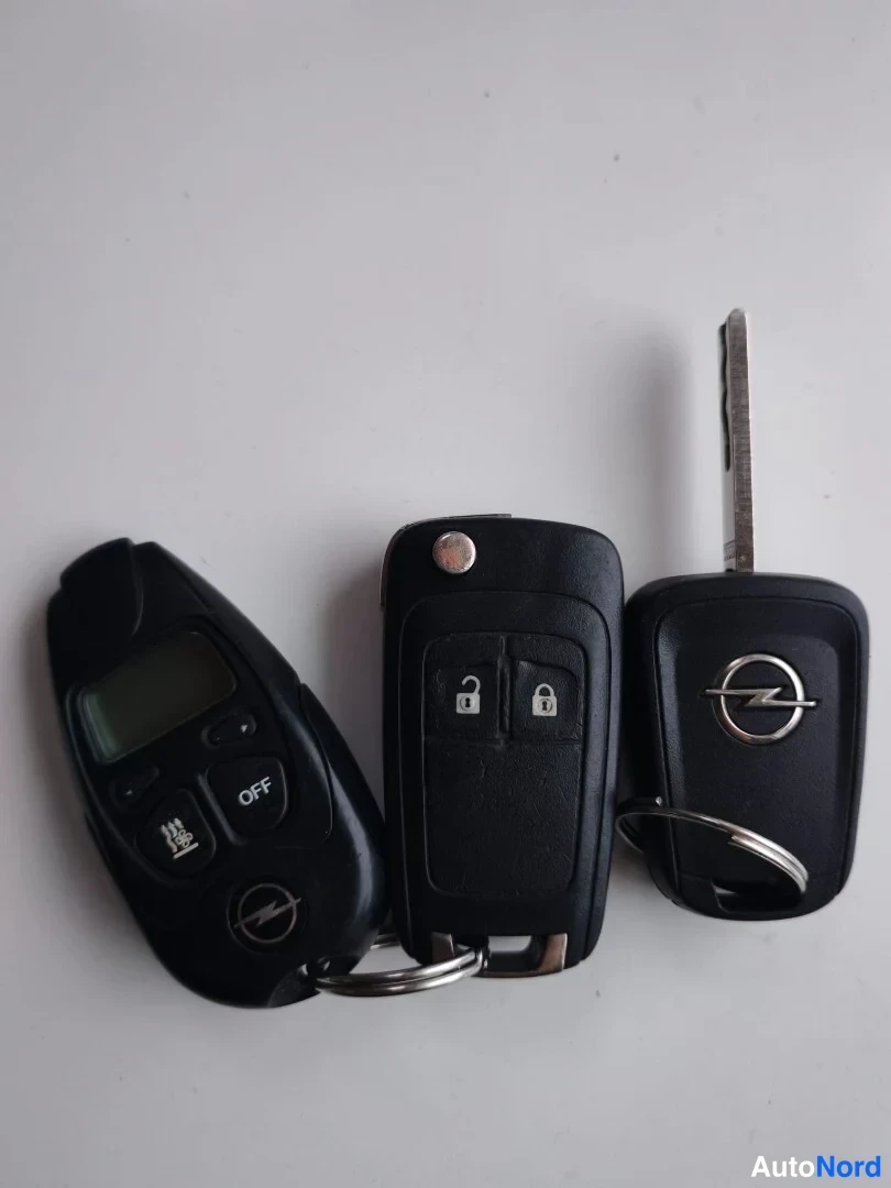 Muu: Valokuvassa kolme mustaa avainnilkkaa: Opel-merkkiset kahden napin lohkoavaimet sekä erillinen alumiininen avain, jotka ovat samassa avainrenkaassa.