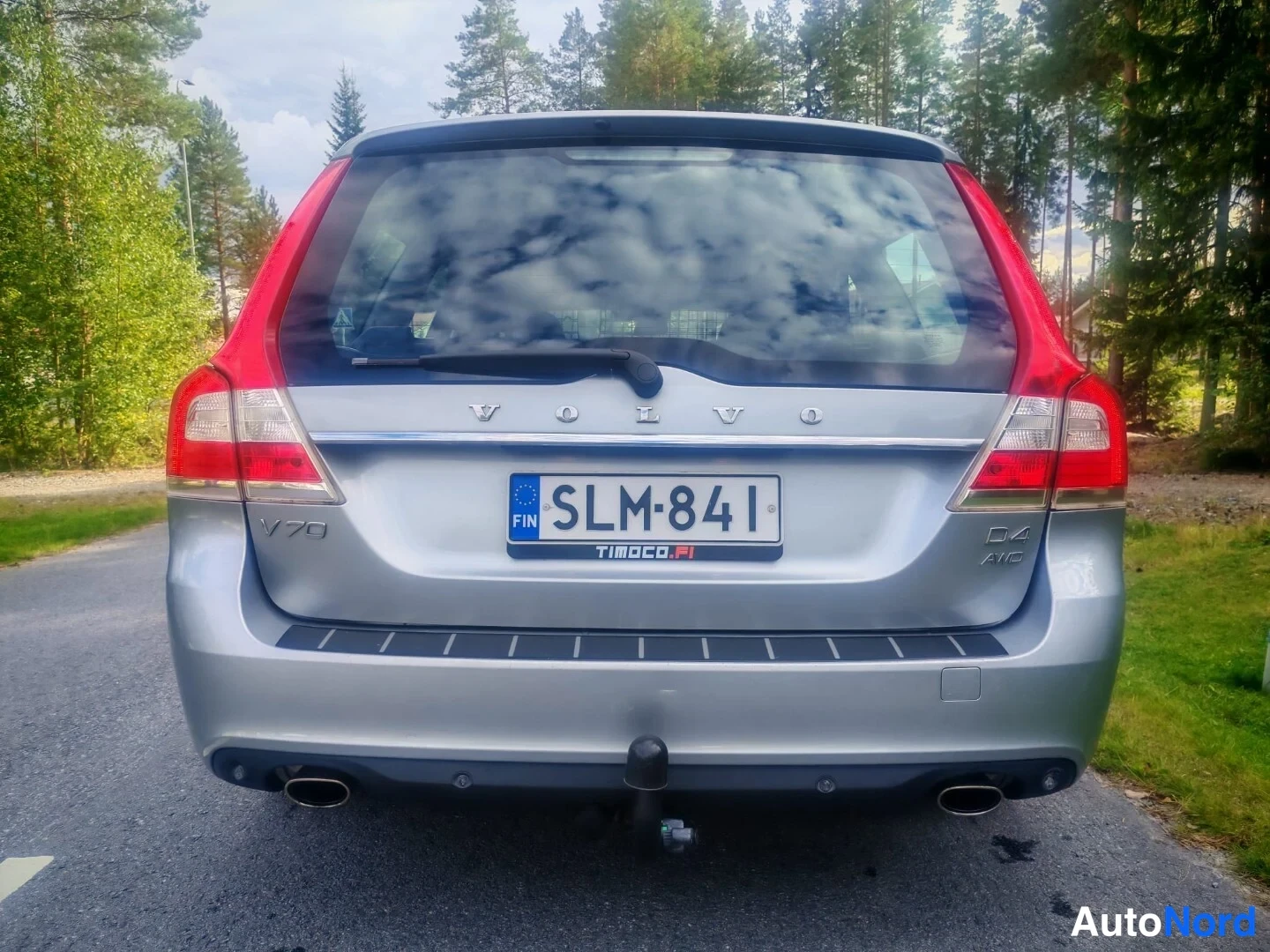 Takaa: Hopeanharmaan farmariauton takaosan suora kuva. Rekisterikilpi, VOLVO-teksti ja D4 AWD-merkinnät takaluukussa, kaksinkertaiset pakoputket ja vetokoukku näkyvät.