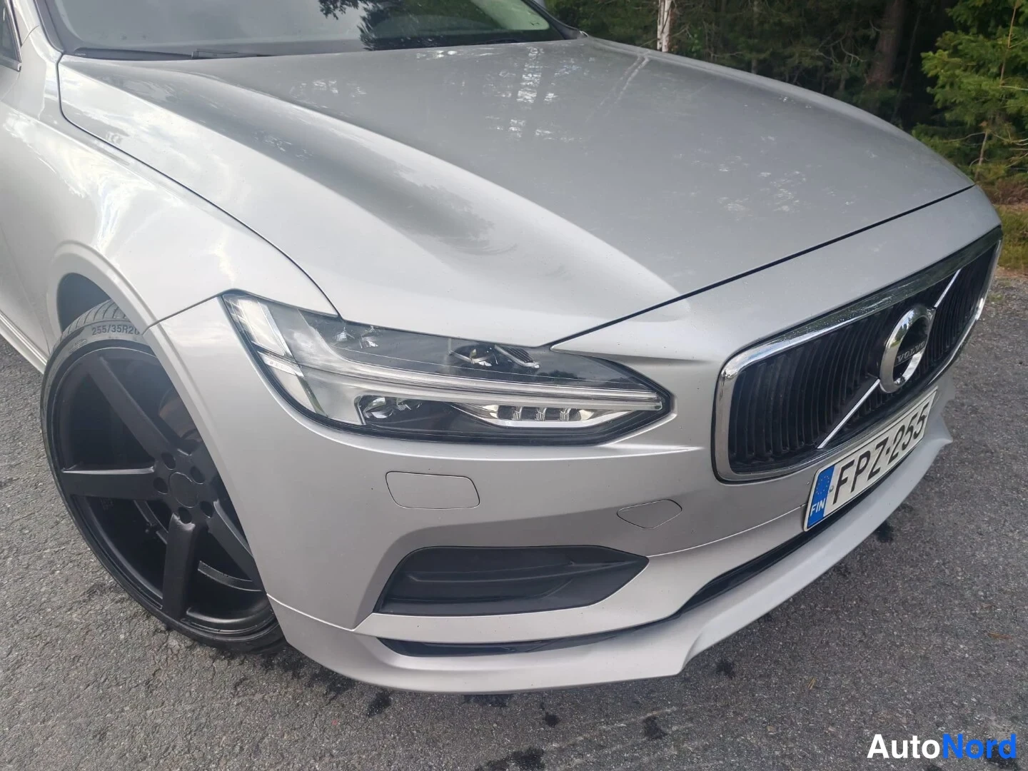 Edestä: Detailed front view showing LED headlight assembly, grille and license plate area of silver car