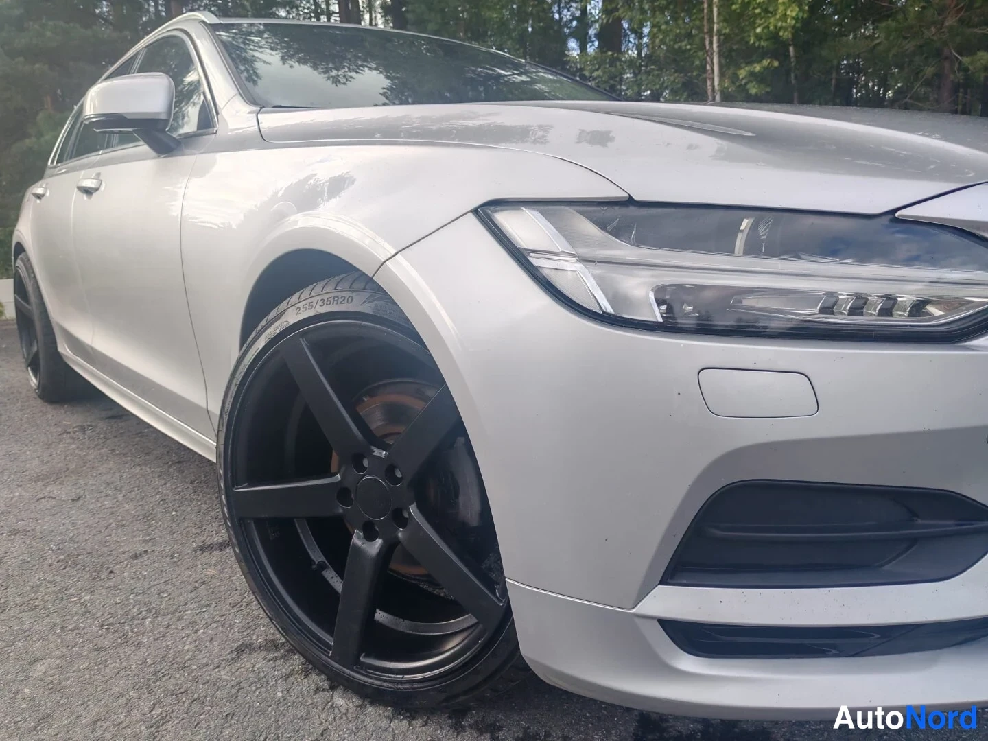 Etuviisto, nokka oikealle: Front three-quarter detail of silver car showing headlight design and black multi-spoke wheel with brake caliper