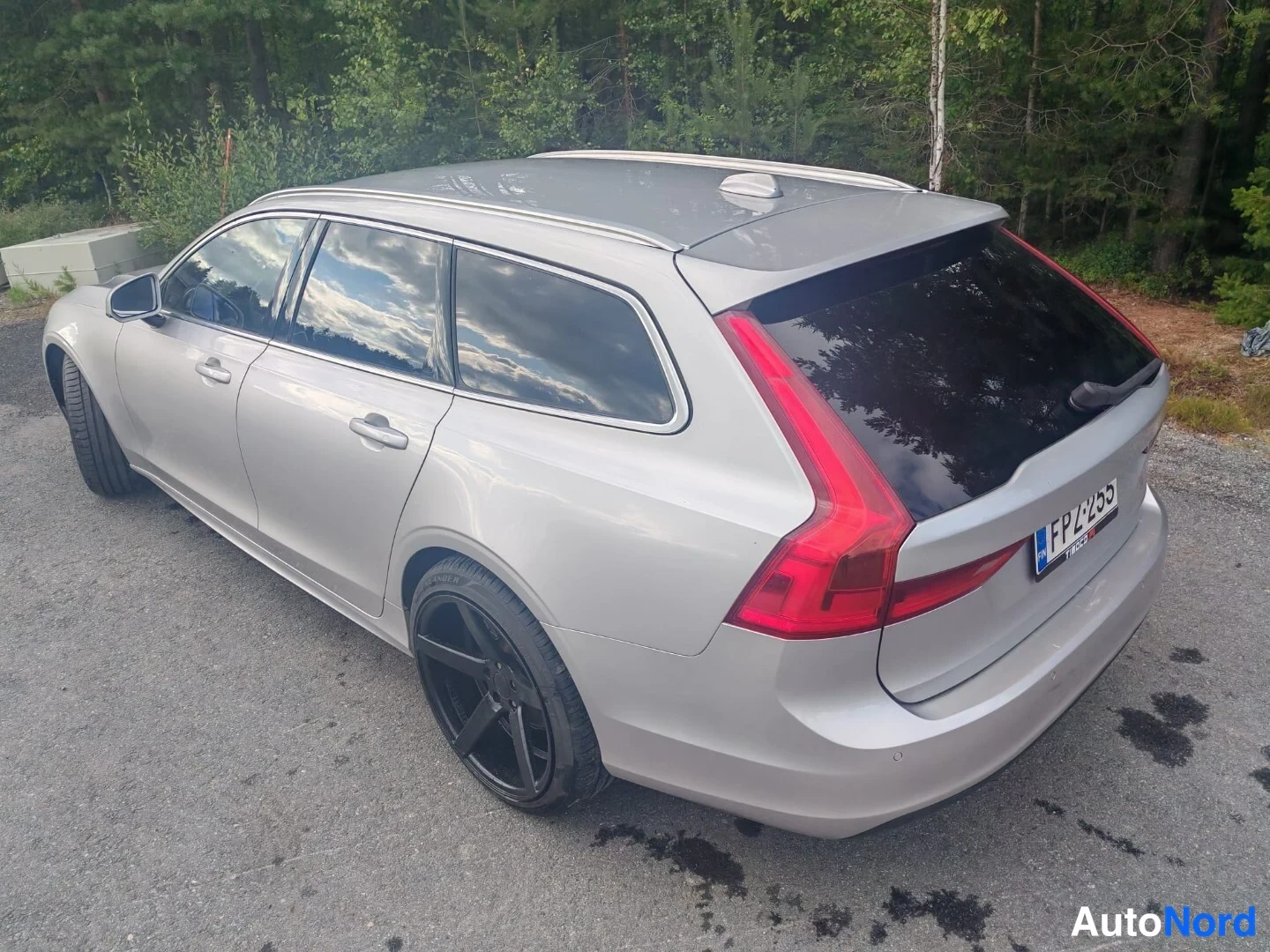 Takaviisto: Hopea farmariauto yläviistosti takaviistosta kuvattuna: punaiset takavalot, tummat lasit ja musta vanne.