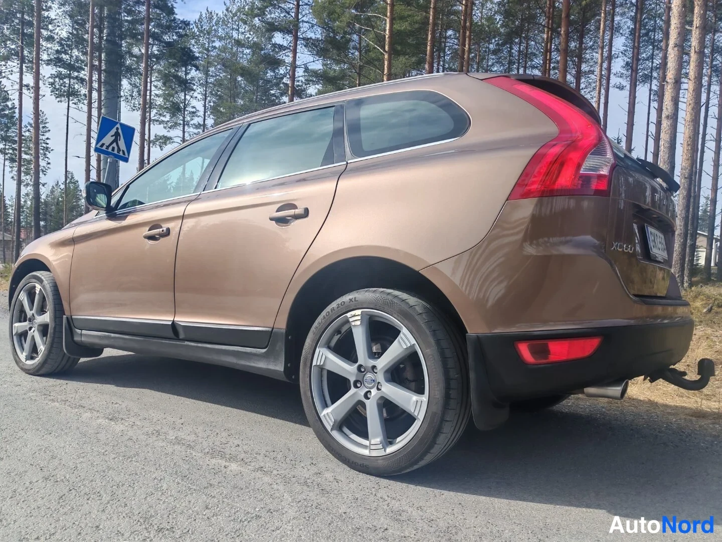 Takaviisto: Ruskea farmarimallinen automme takakulmasta, XC60-merkintä ja takavalo näkyvät.