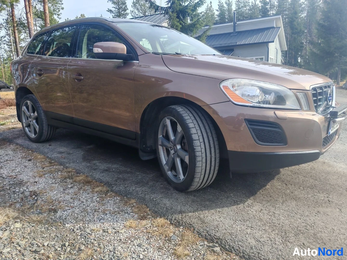 Etuviisto, nokka oikealle: Volvo XC60 kulmassa edestä oikealta kuvattuna, ruskea koriväri.