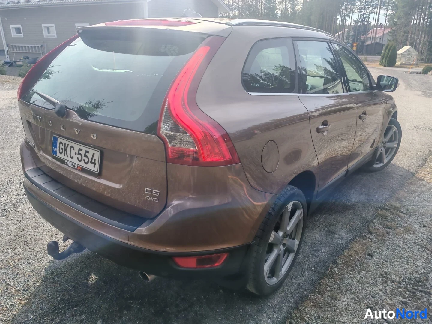 Takaviisto: Takaa ja oikeasta kulmasta otettu kuva ruskeasta Volvosta. Takavalot kirkkaanpunaiset, vetoputki alla, ja D5 AWD -logo näkyvissä takaluukussa.