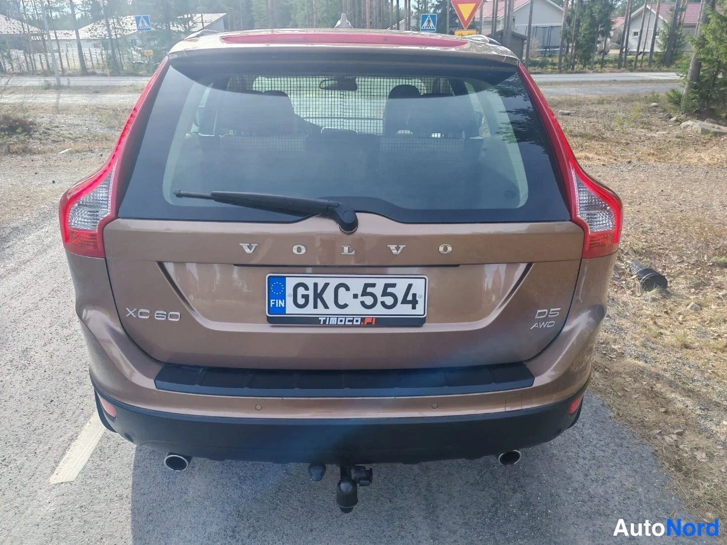 Takaviisto: Kuva auton takakulmasta. Takavalot ovat punaiset ja puskurissa on kelkkateline (TOW_BAR) sekä pakoputket. Luokitusmerkit XC60, D5 ja AWD lukevat perässä. Vakuut