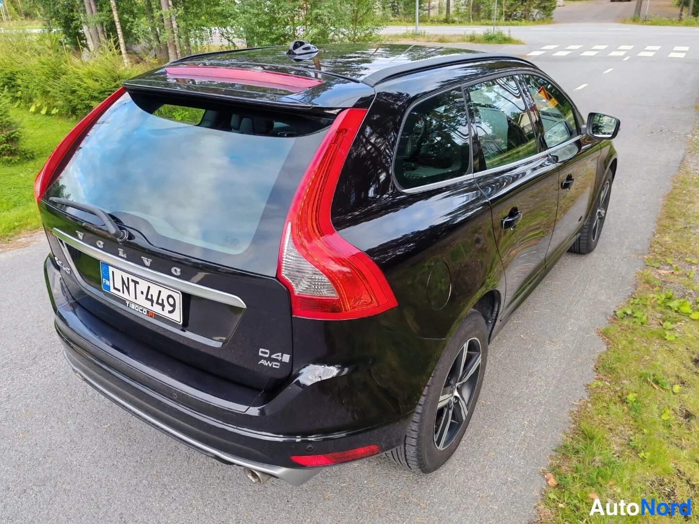 Takaviisto: Mustan farmariauton takaosa kulmasta: rekisterikilpi, VOLVO-teksti ja D4 AWD-merkintä takaluukussa, punaiset takavalot.