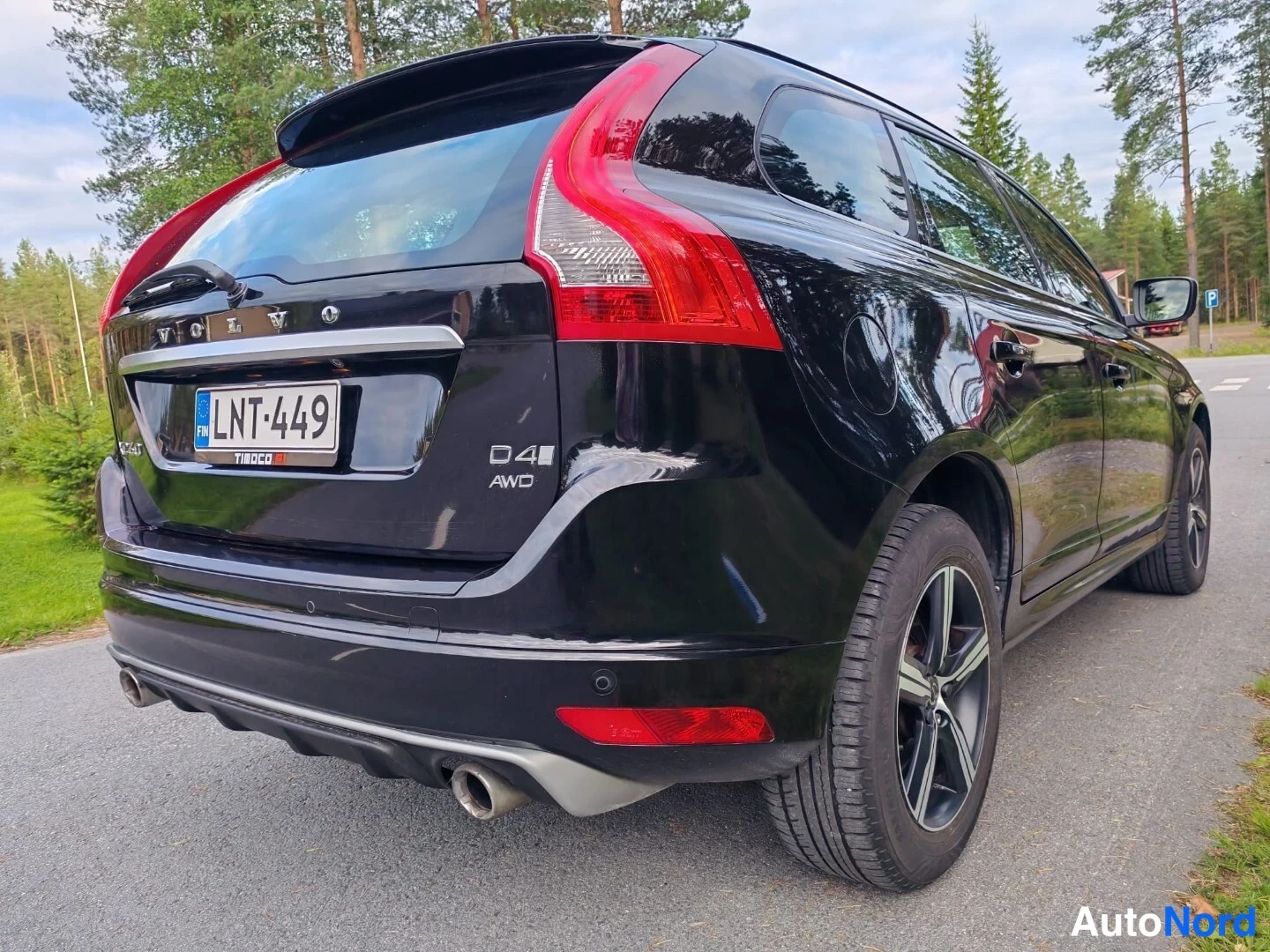 Takaviisto: Mustan farmariauton takaosa kulmasta: rekisterikilpi, VOLVO-teksti, D4 AWD-merkintä, punaiset takavalot ja kaksiosainen pakoputki.
